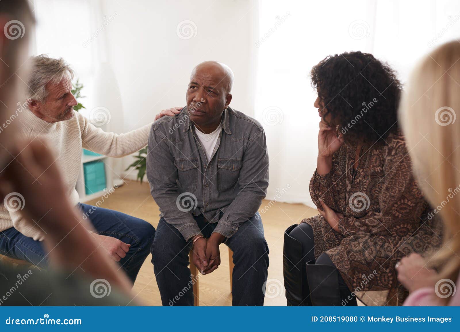 Group Consoling Man Speaking at Support Group Meeting for Mental Health