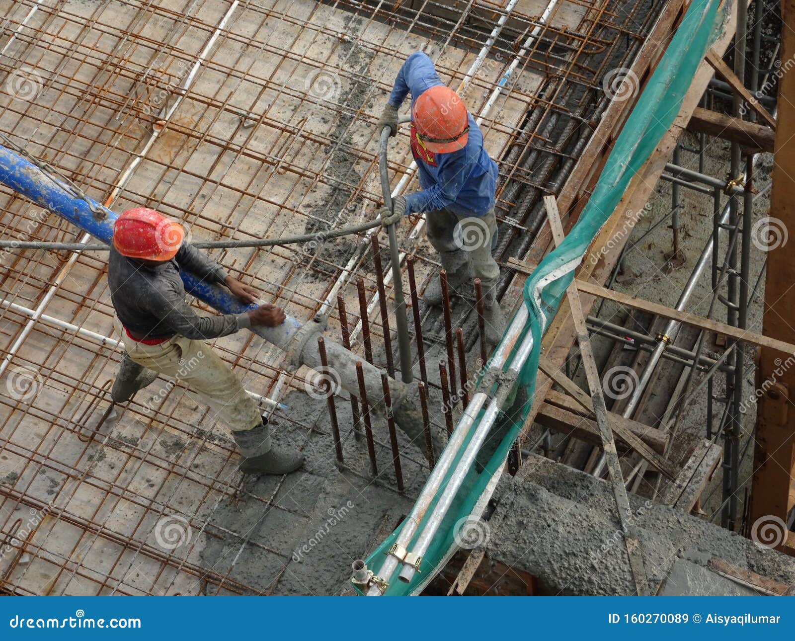 Group of Construction Workers Pouring Wet Concrete Using the Concrete