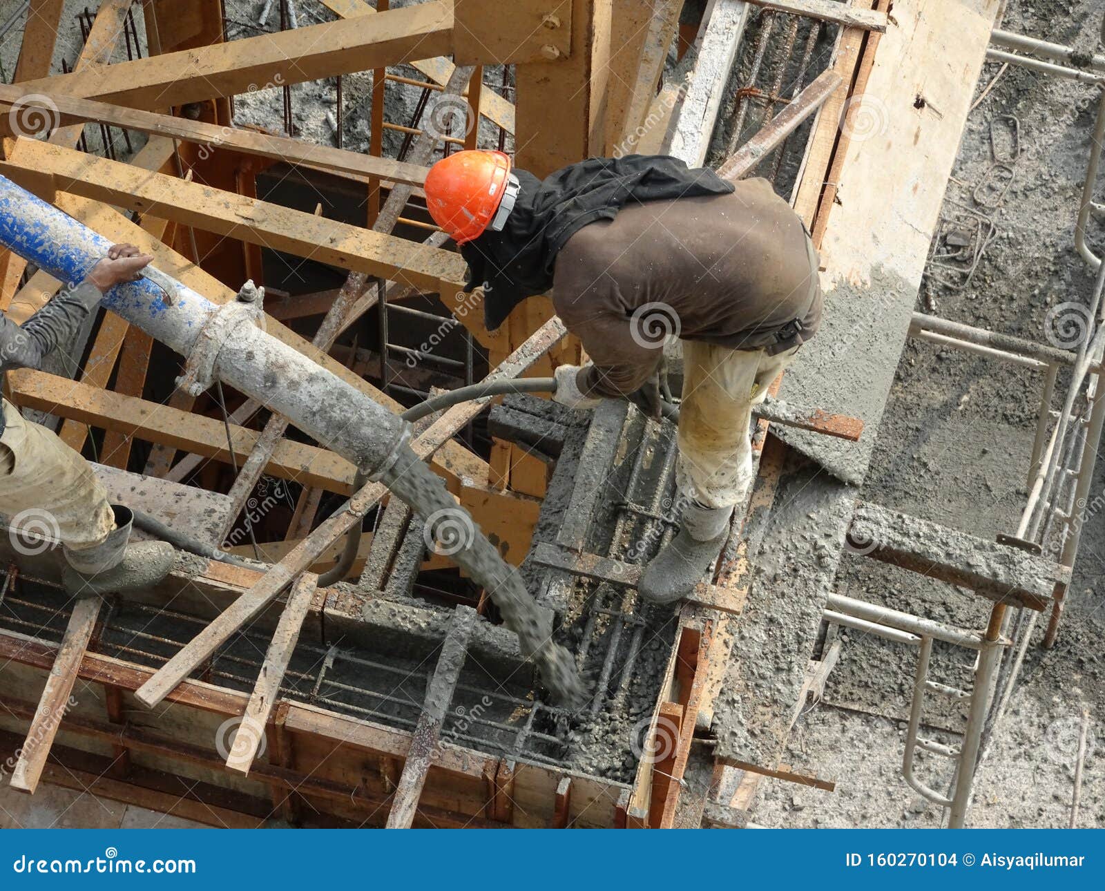 Group of Construction Workers Pouring Wet Concrete Using the Concrete