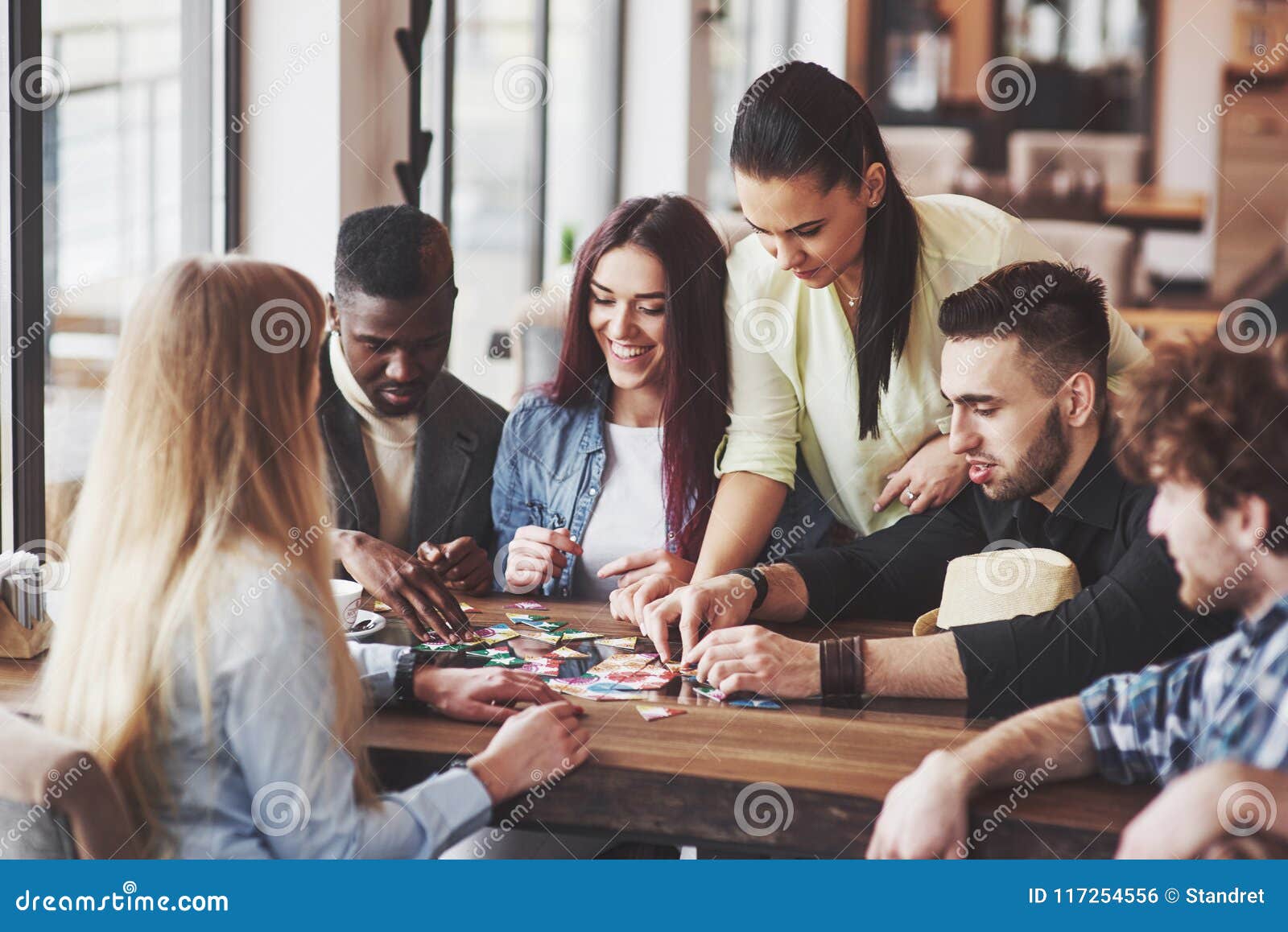 Group Of Creative Friends Sitting At Wooden Table People Having Fun