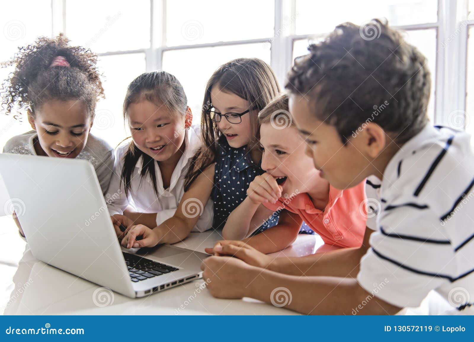 group of curious children watching stuff on the laptop screen