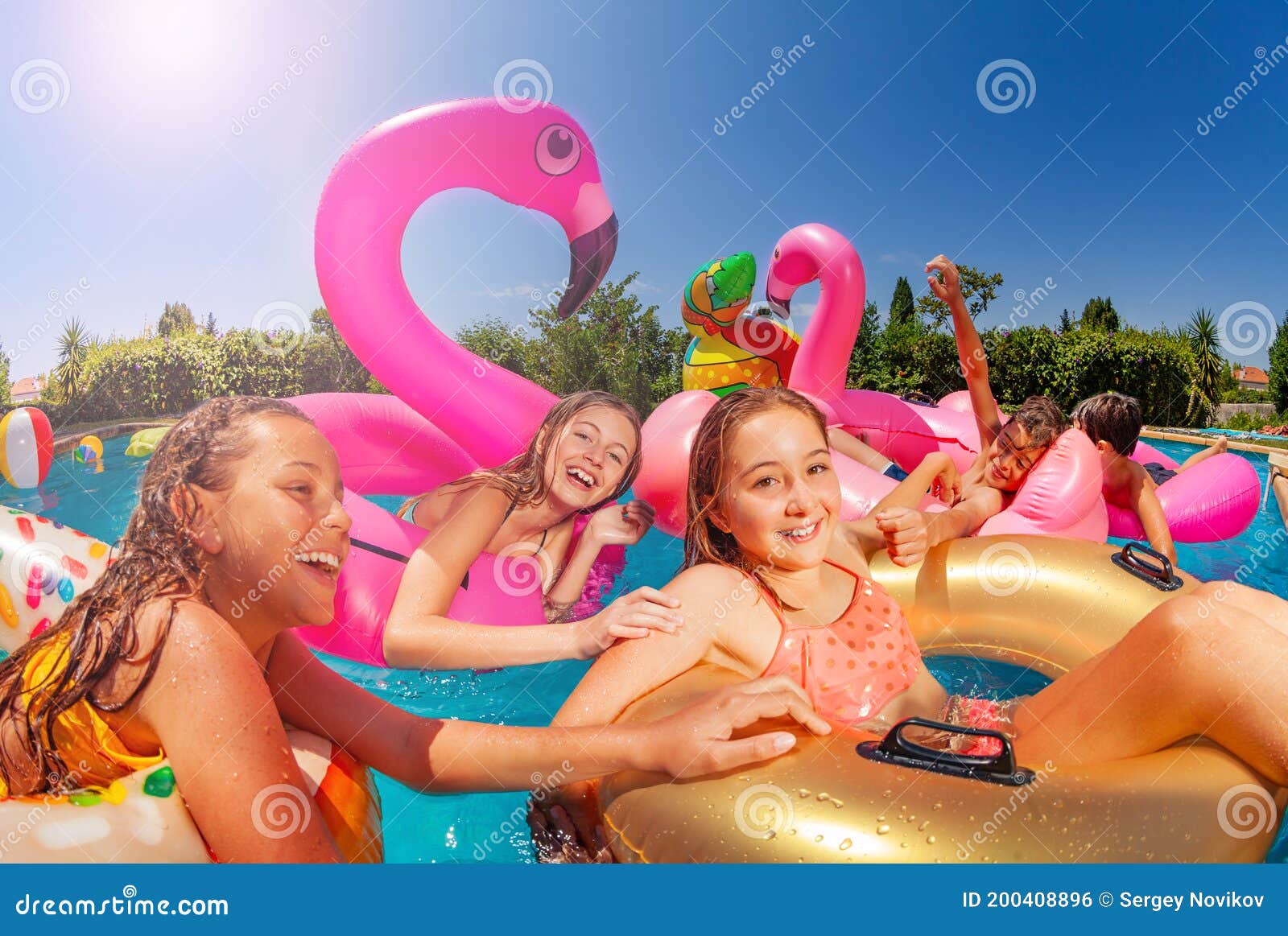 group of cute kids swim in pool on inflatable toys