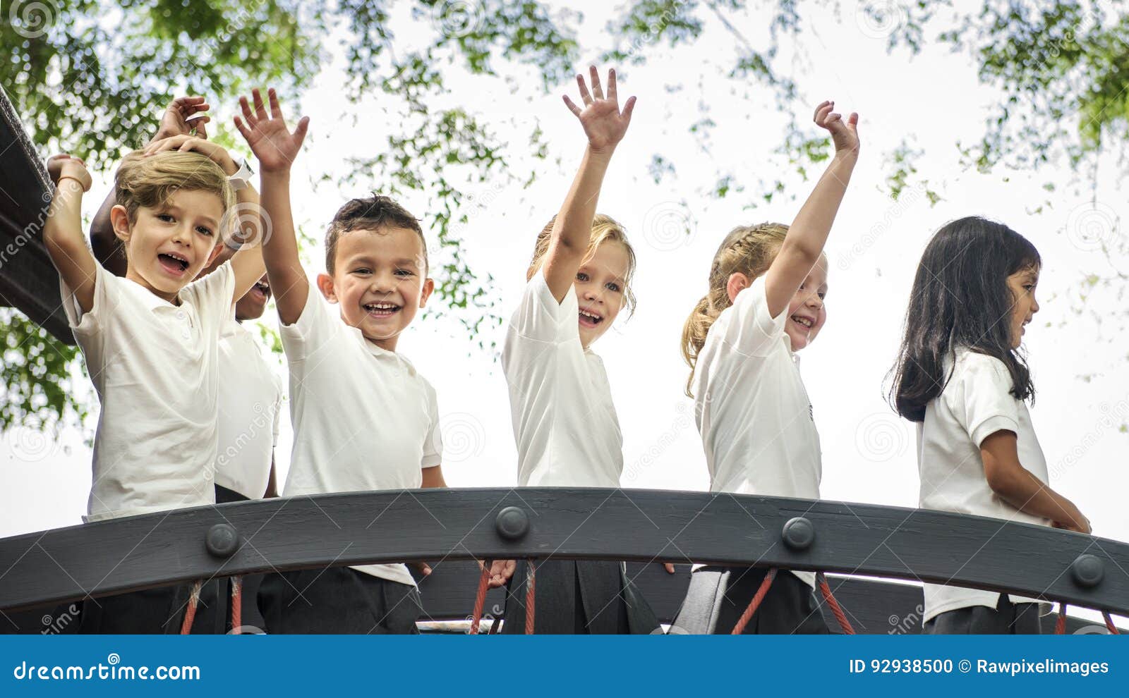 Group of Diverse Kindergarten Students with Arms Raised Stock Photo