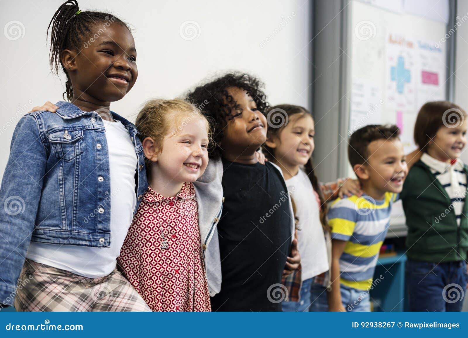 group of diverse kindergarten students standing together in classroom