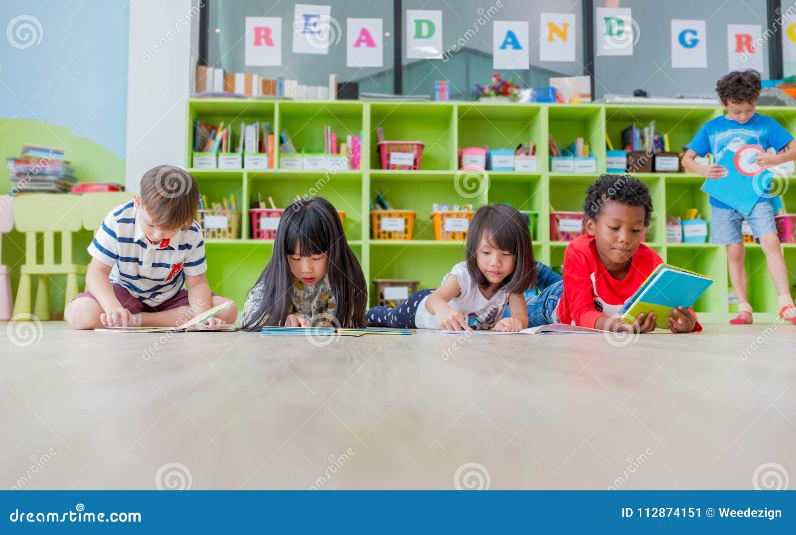 group of diversity kid lay down on floor and reading tale book i