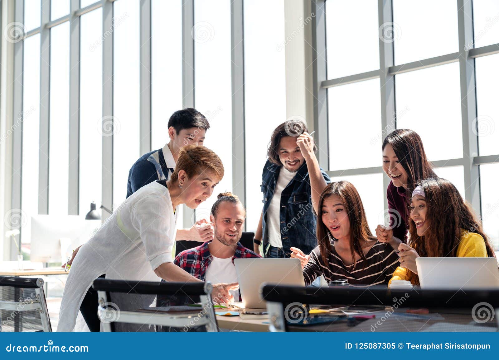 group of diversity people team smiling and excited in success work with laptop at modern office.