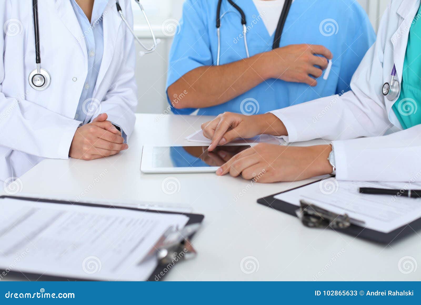 group of doctors at medical meeting. close up of physician using touch pad or tablet computer