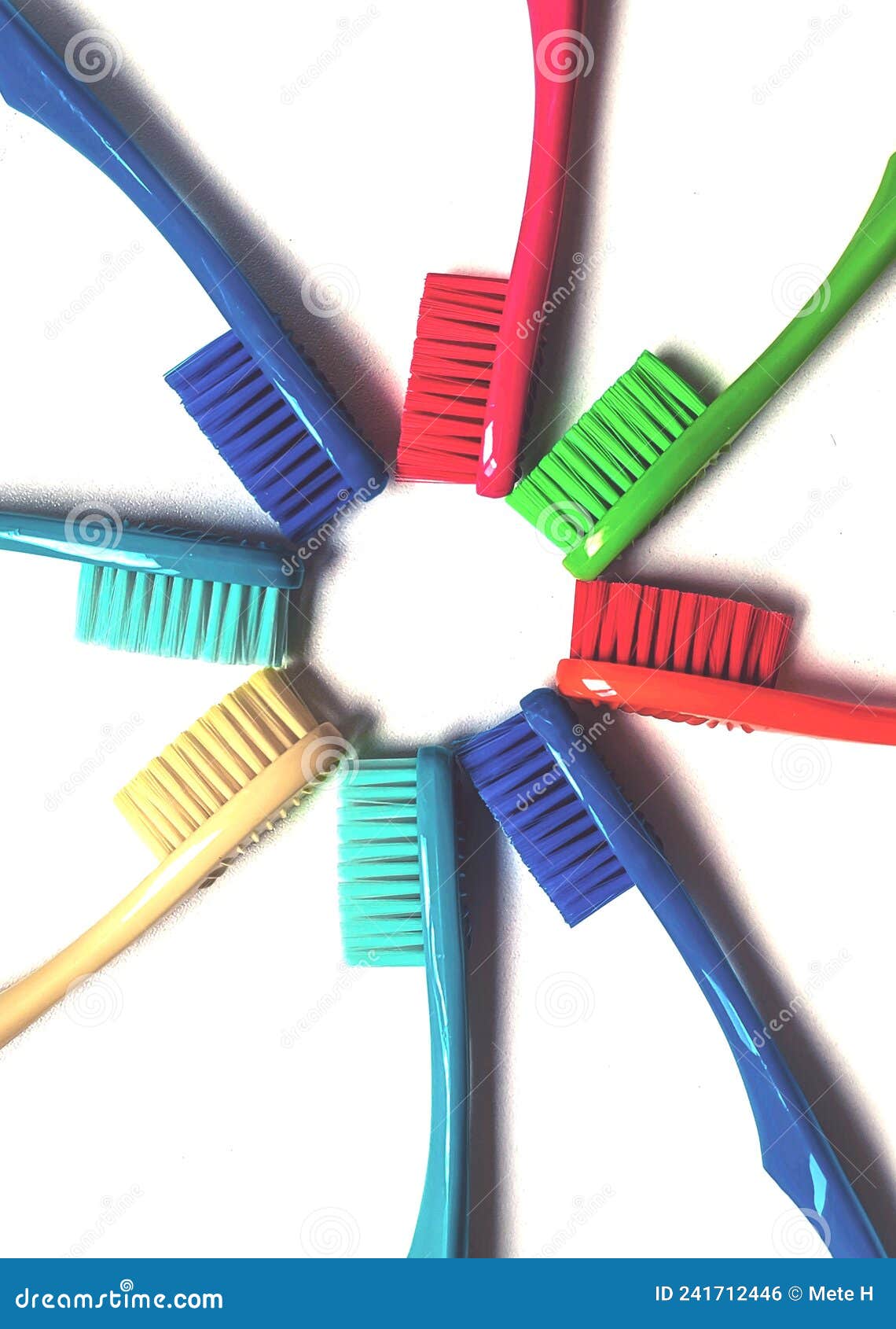 eight toothbrushes of various colors arranged in a star  on a white background.