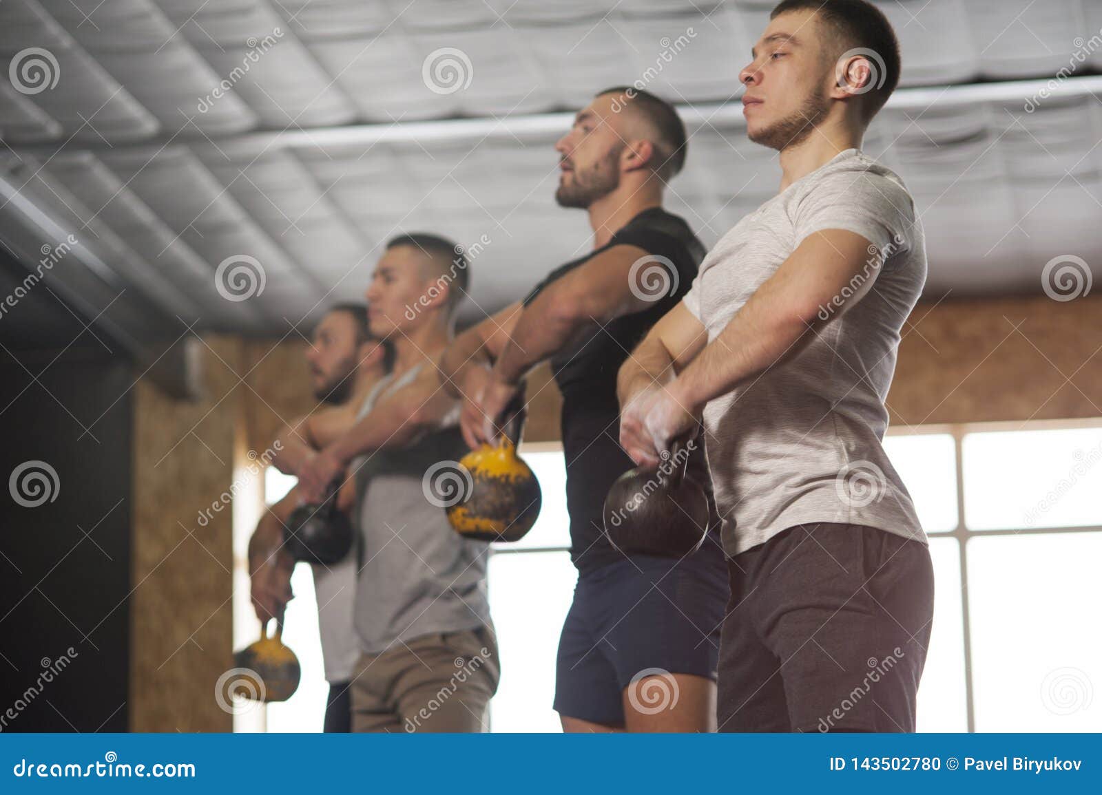Group of Fit and Focused Men Training with Kettlebells. Stock Photo Image of athlete, friends