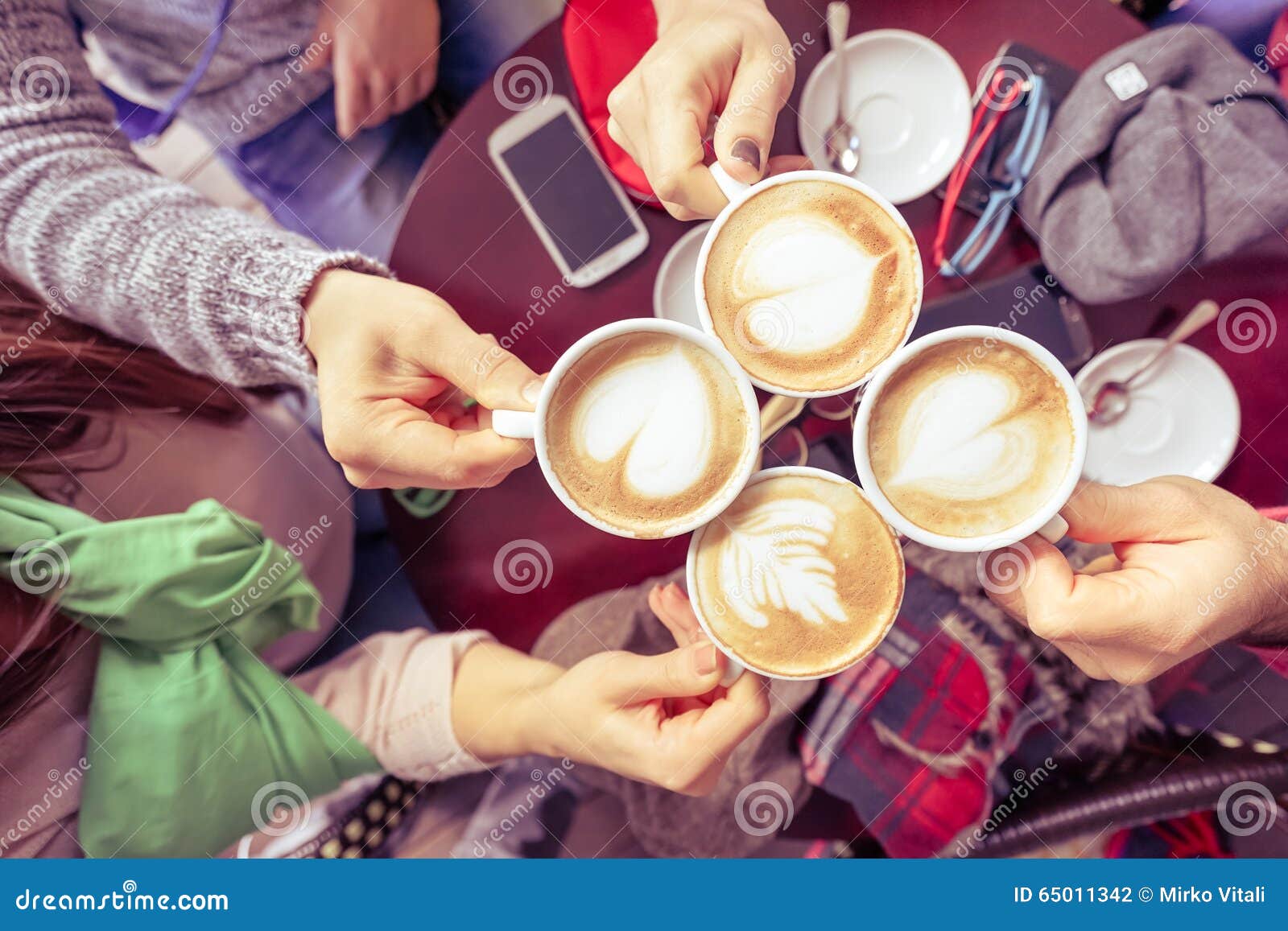 group of friends drinking cappuccino at coffee bar restaurant