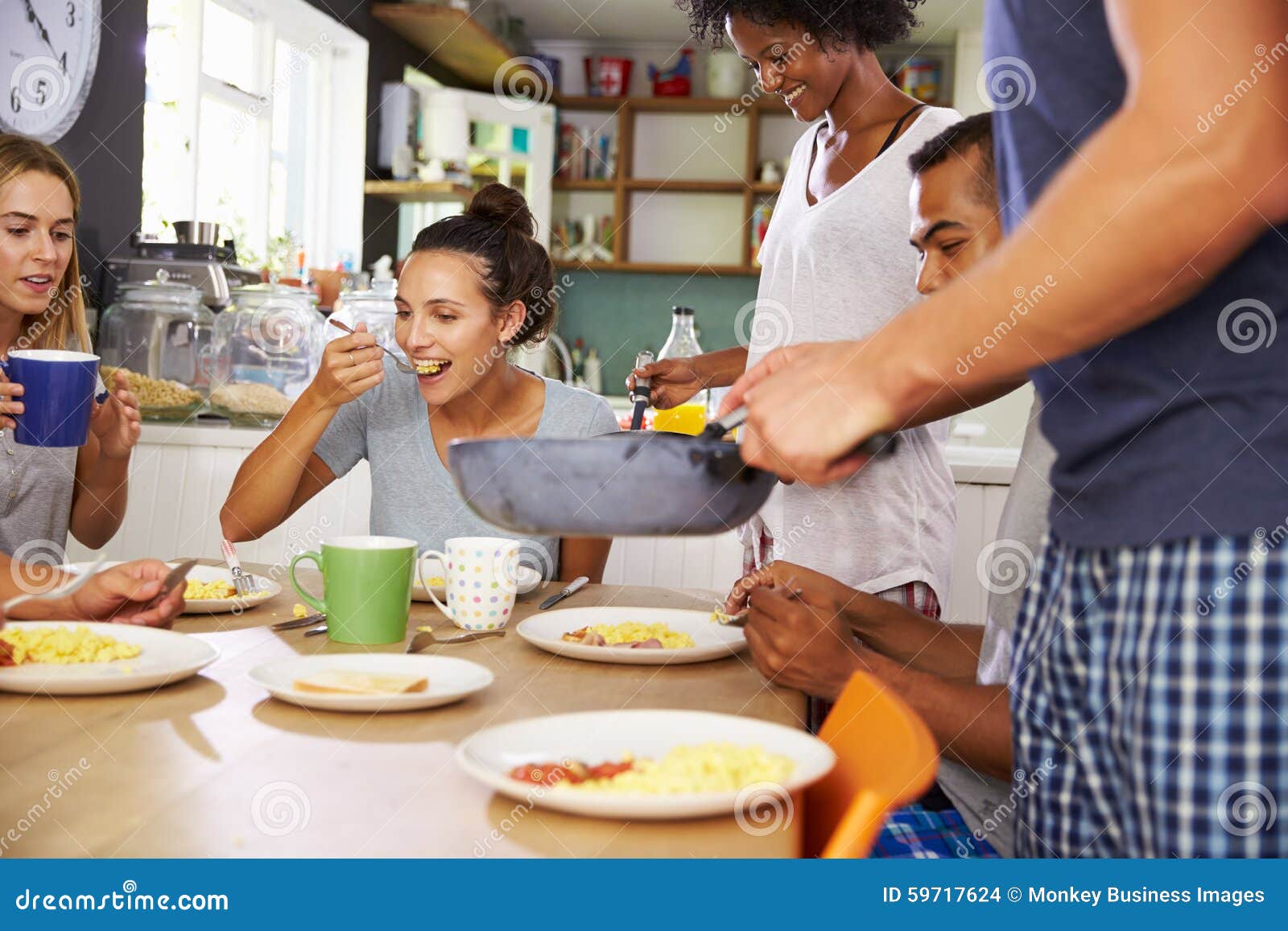 Group of Friends Enjoying Breakfast in Kitchen Together Stock Photo