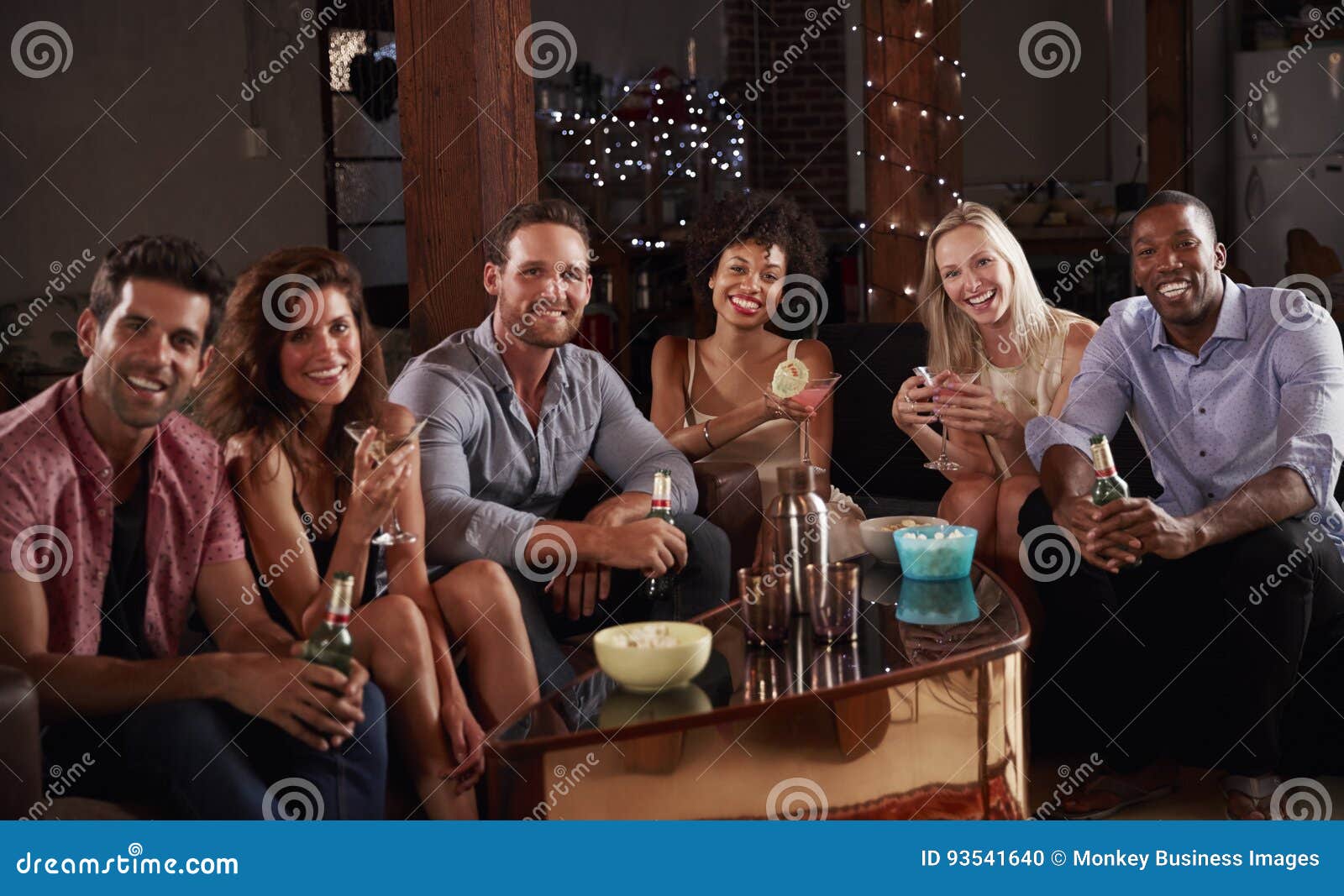 Group of Friends at a House Party Sit Looking To Camera Stock Photo
