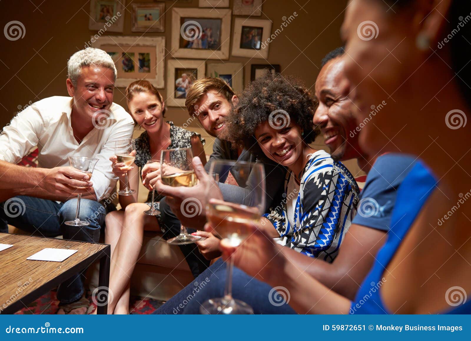Group of Friends Sitting Around a Table at House Party Stock Image
