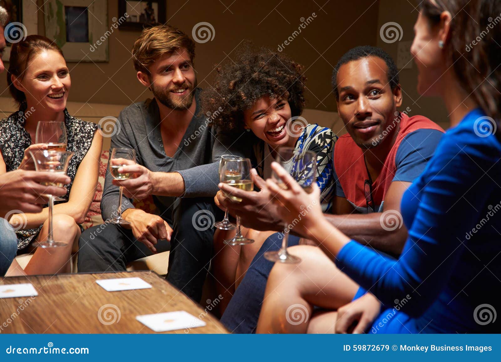 Group of Friends Sitting Around a Table at House Party Stock Image