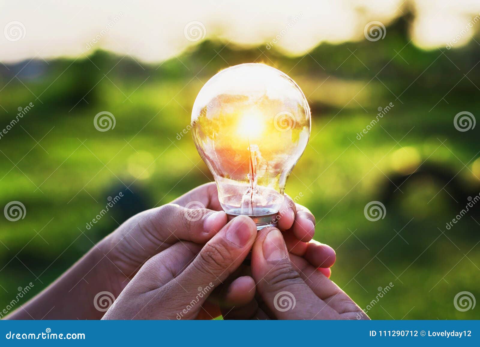Group Hand Holding Lightbulb with Sunset. Concept Idea Solar Ene Stock