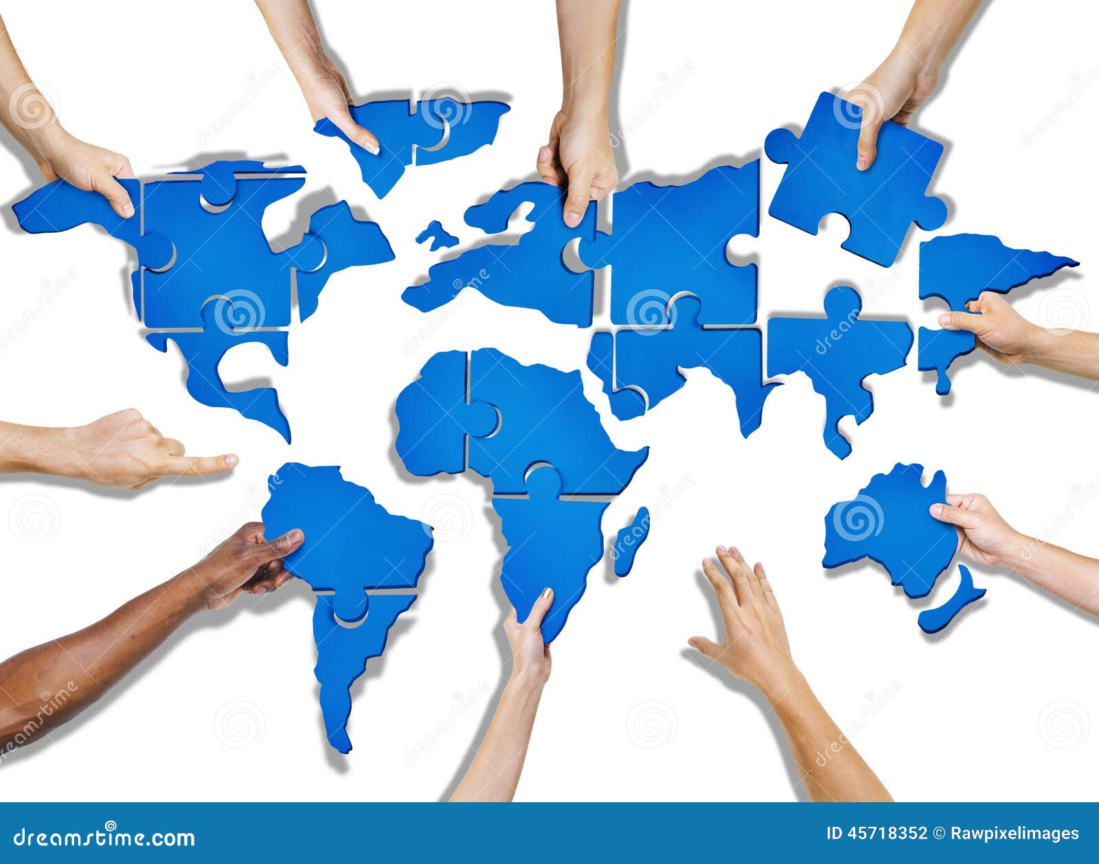 group of hands holding jigsaw puzzle forming world