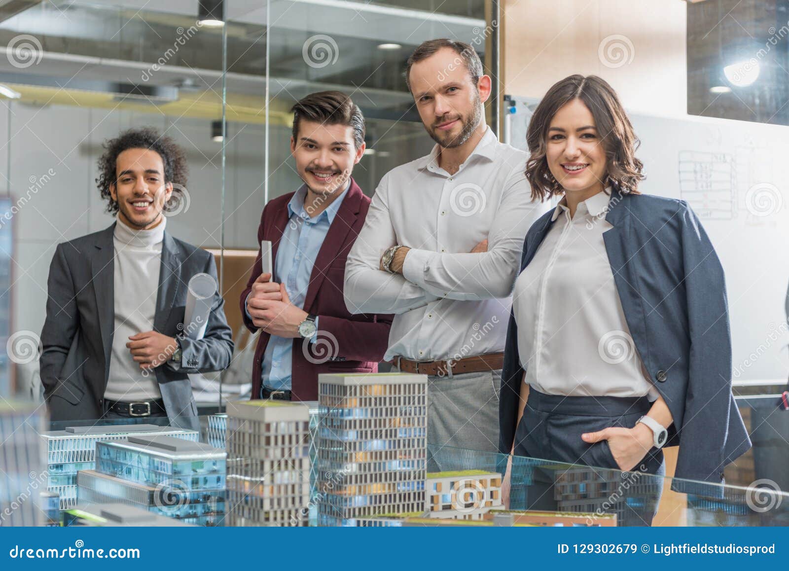 Group of Happy Architects Standing Next To Building Models Stock Image