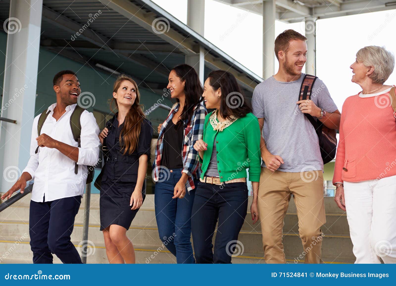 a group of happy teachers walking in a school corridor