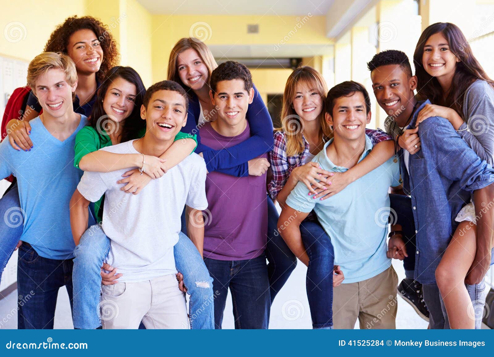 group of high school students giving piggybacks in corridor