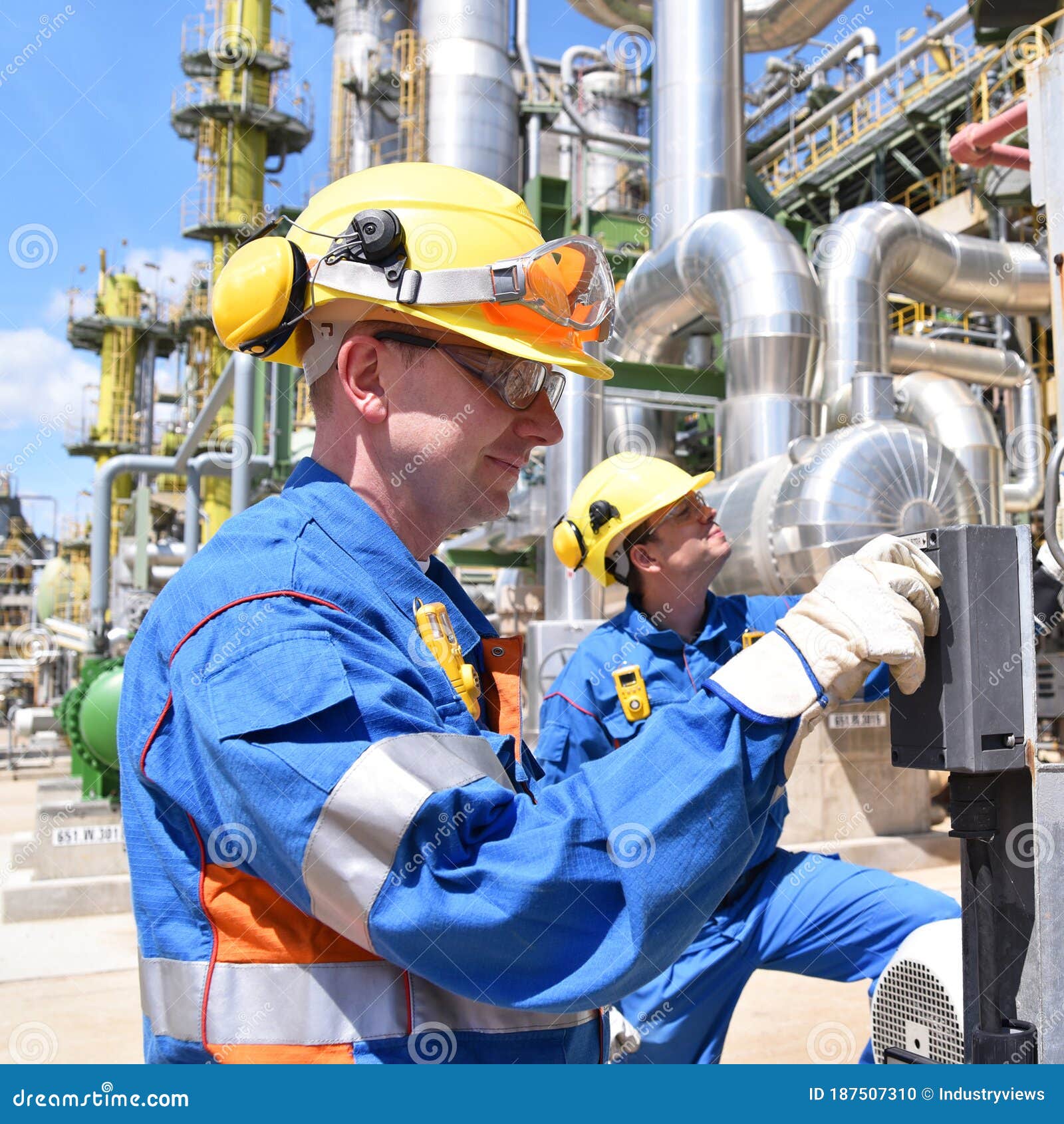 Group of Industrial Workers in a Refinery Oil Processing Equipment