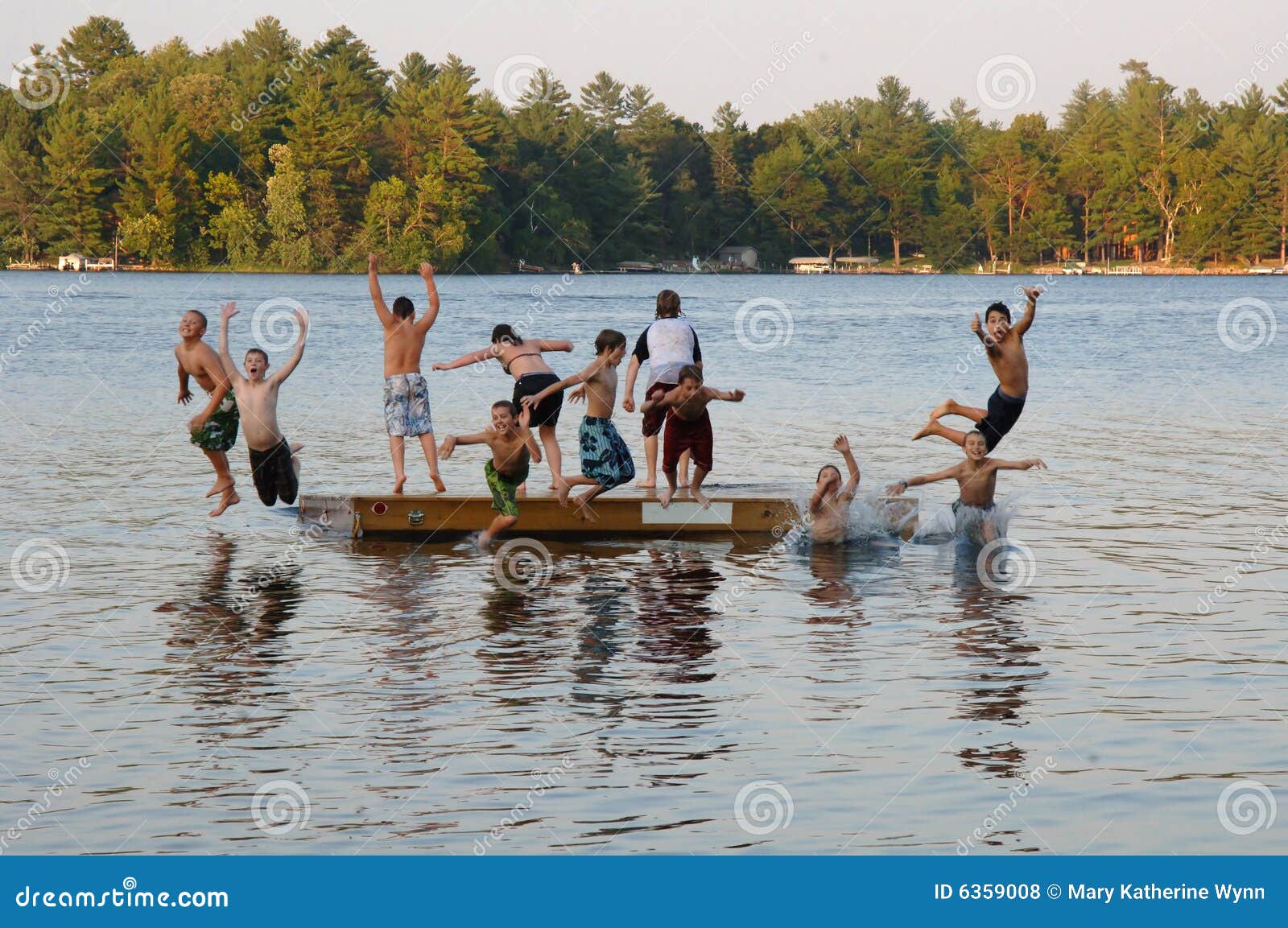 group of kids jumping into lake