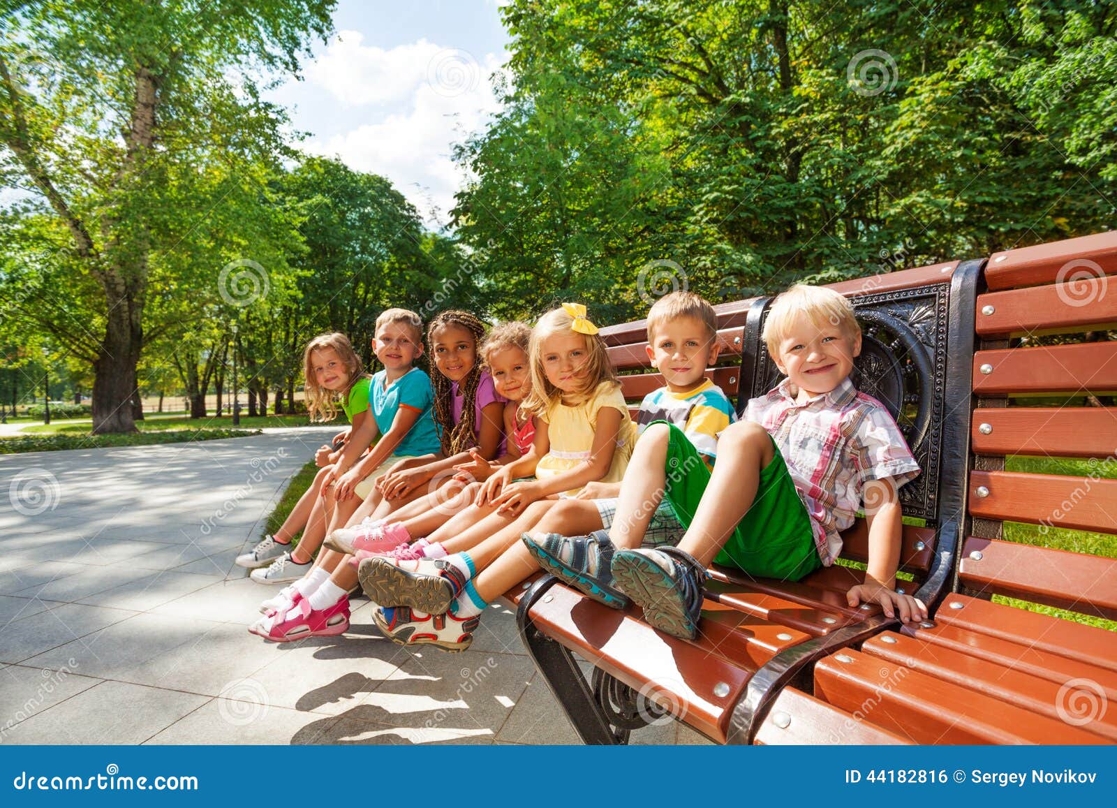 Group Or Kids Rest On Bench In Park Stock Photo - Image 
