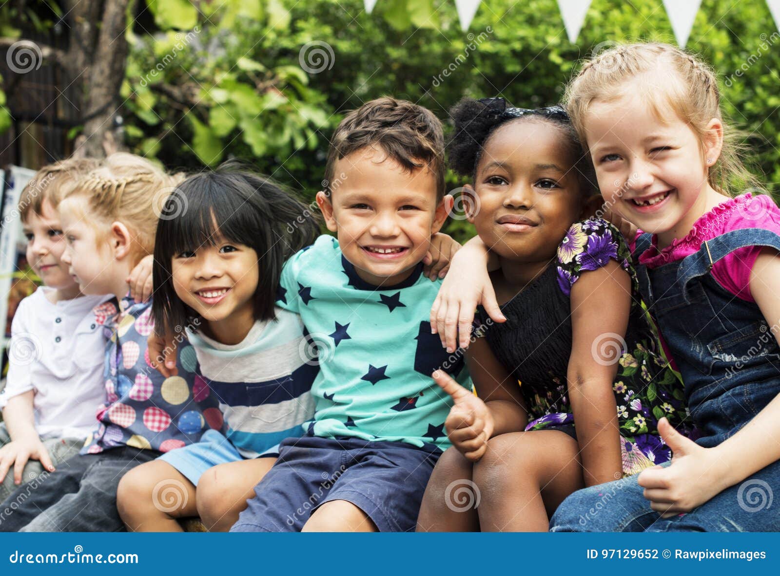 group of kindergarten kids friends arm around sitting and smiling fun