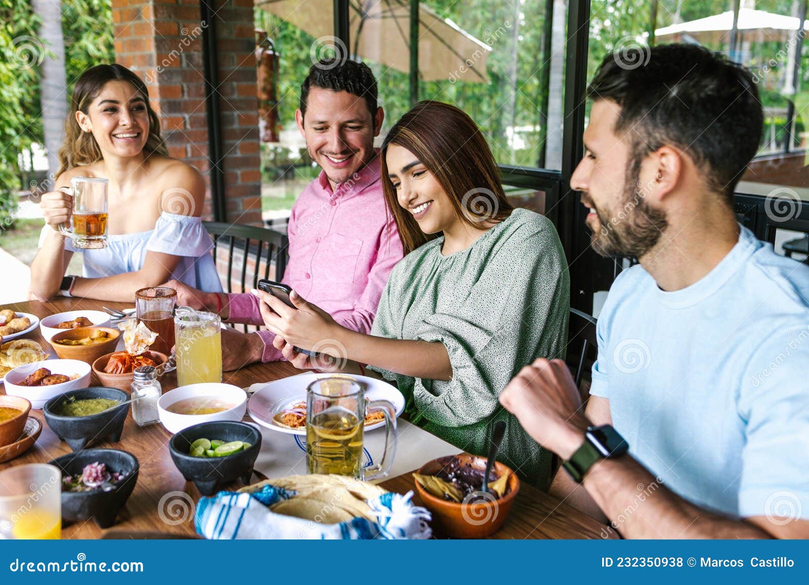 Group of Latin Friends Eating Mexican Food in a Restaurant Terrace in