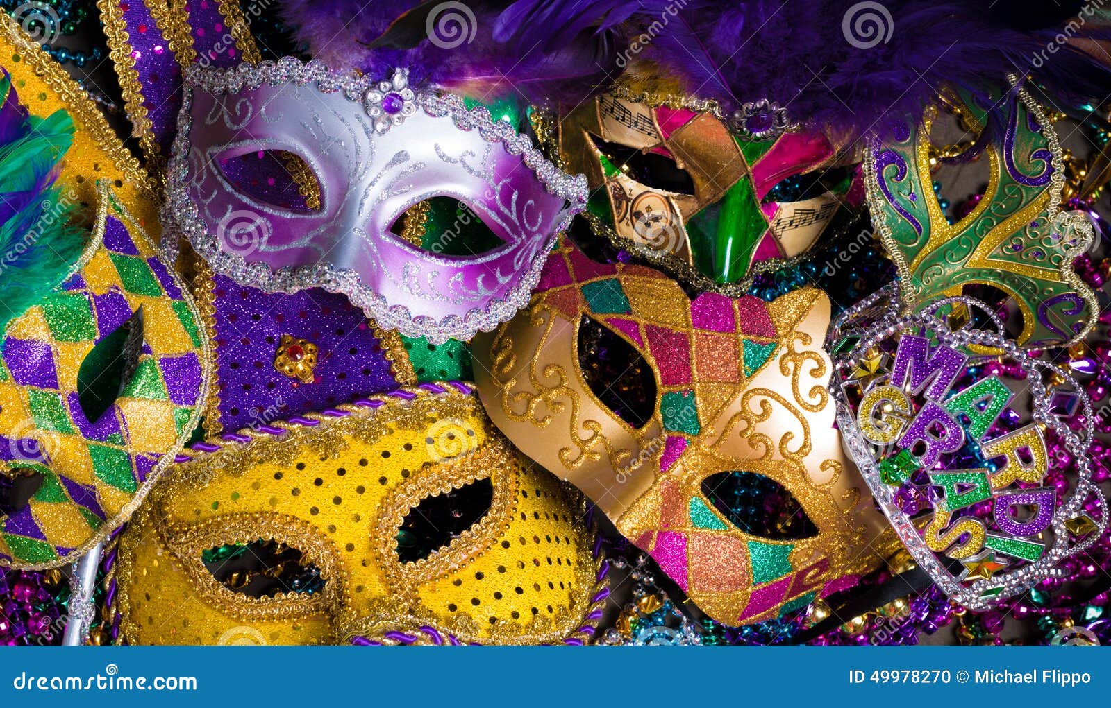 group of mardi gras mask on dark background with beads