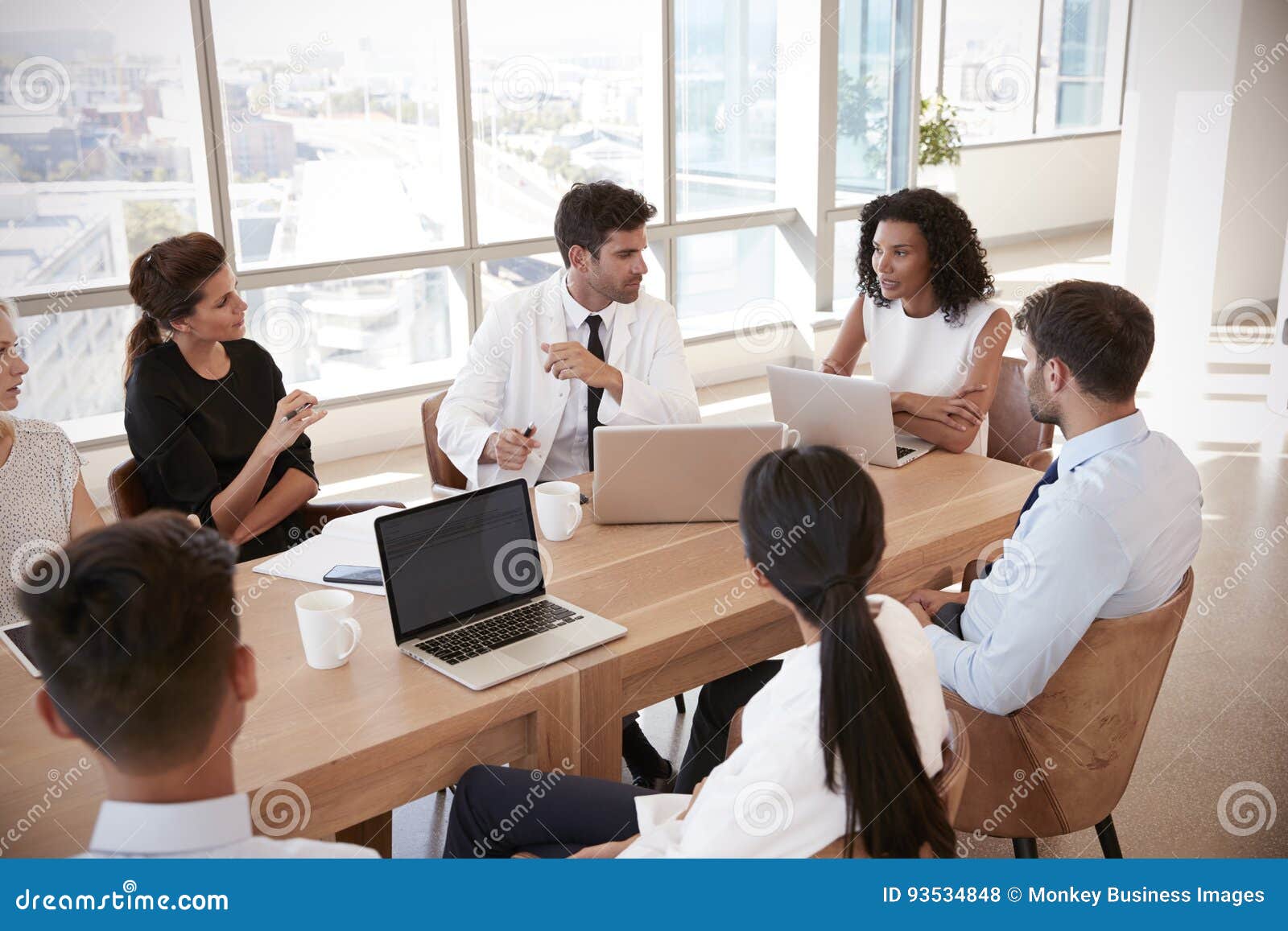 group of medical staff meeting around table in hospital