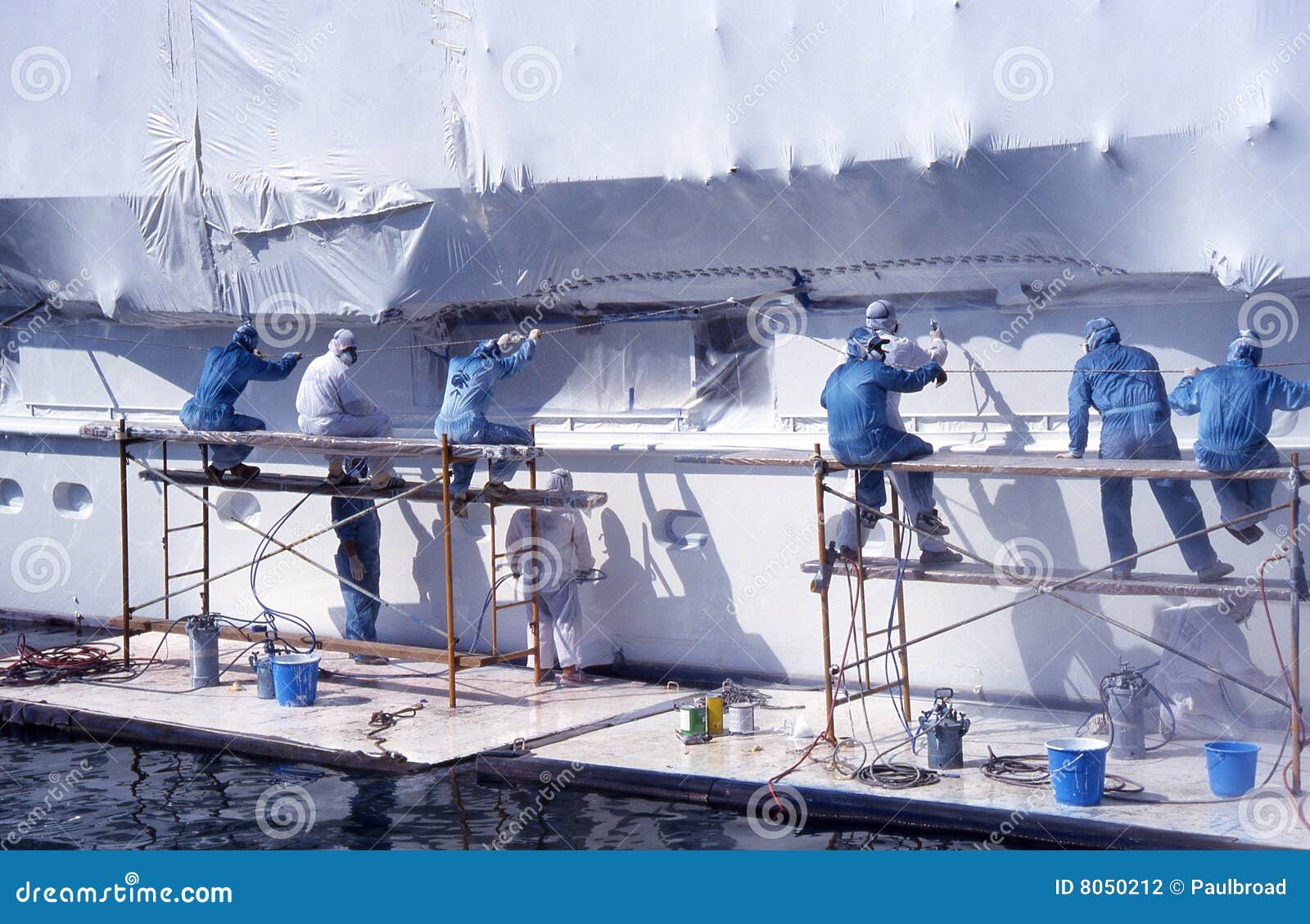 Group of Men in Overalls Painting Boat. Stock Photo Image of goggle