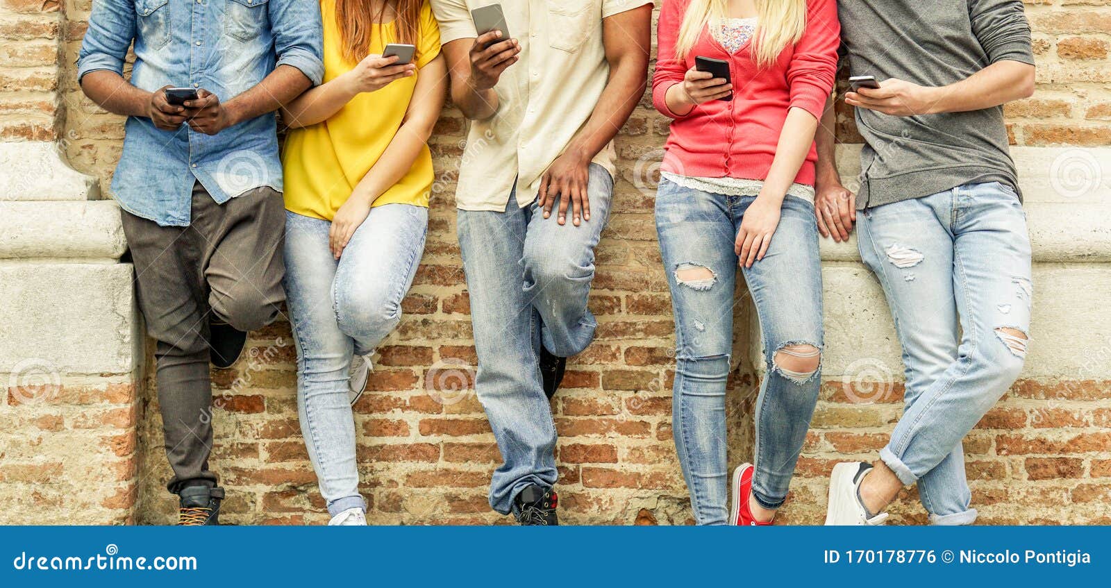 group of multiracial students watching smart mobile phones in university break - young people addiction to new technology trends
