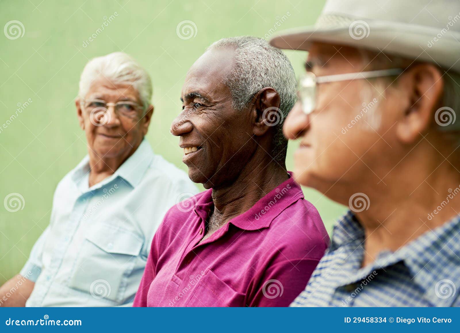 group of old black and caucasian men talking in park