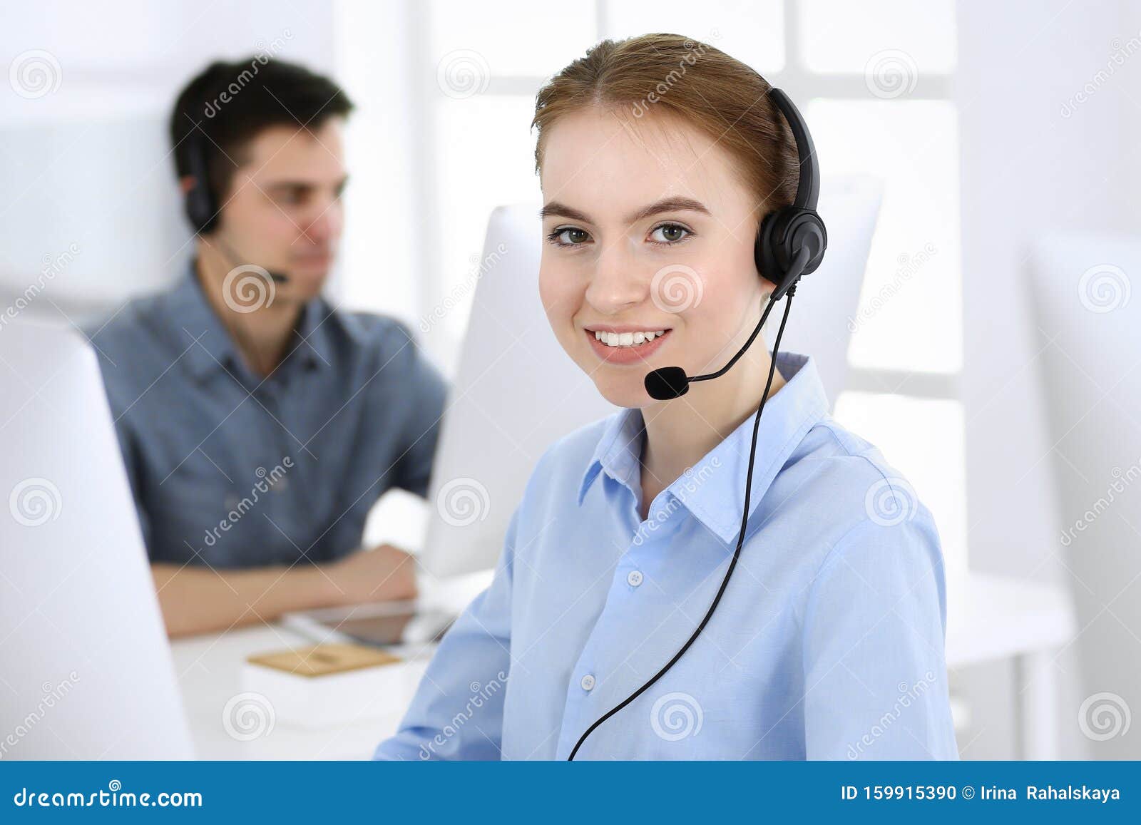 group of operators at work. call center. focus on beautiful woman receptionist in headset at customer service. business
