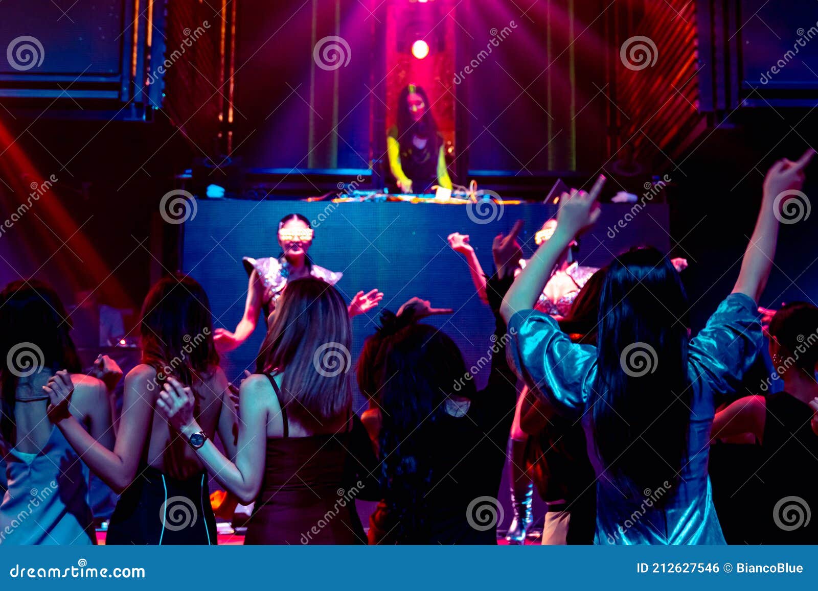 Group of People Dance in Disco Night Club To the Beat of Music from DJ ...