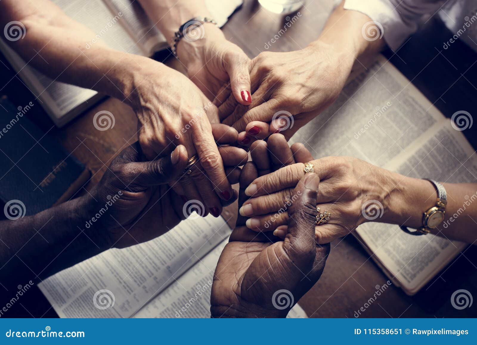 group of people holding hands praying worship believe