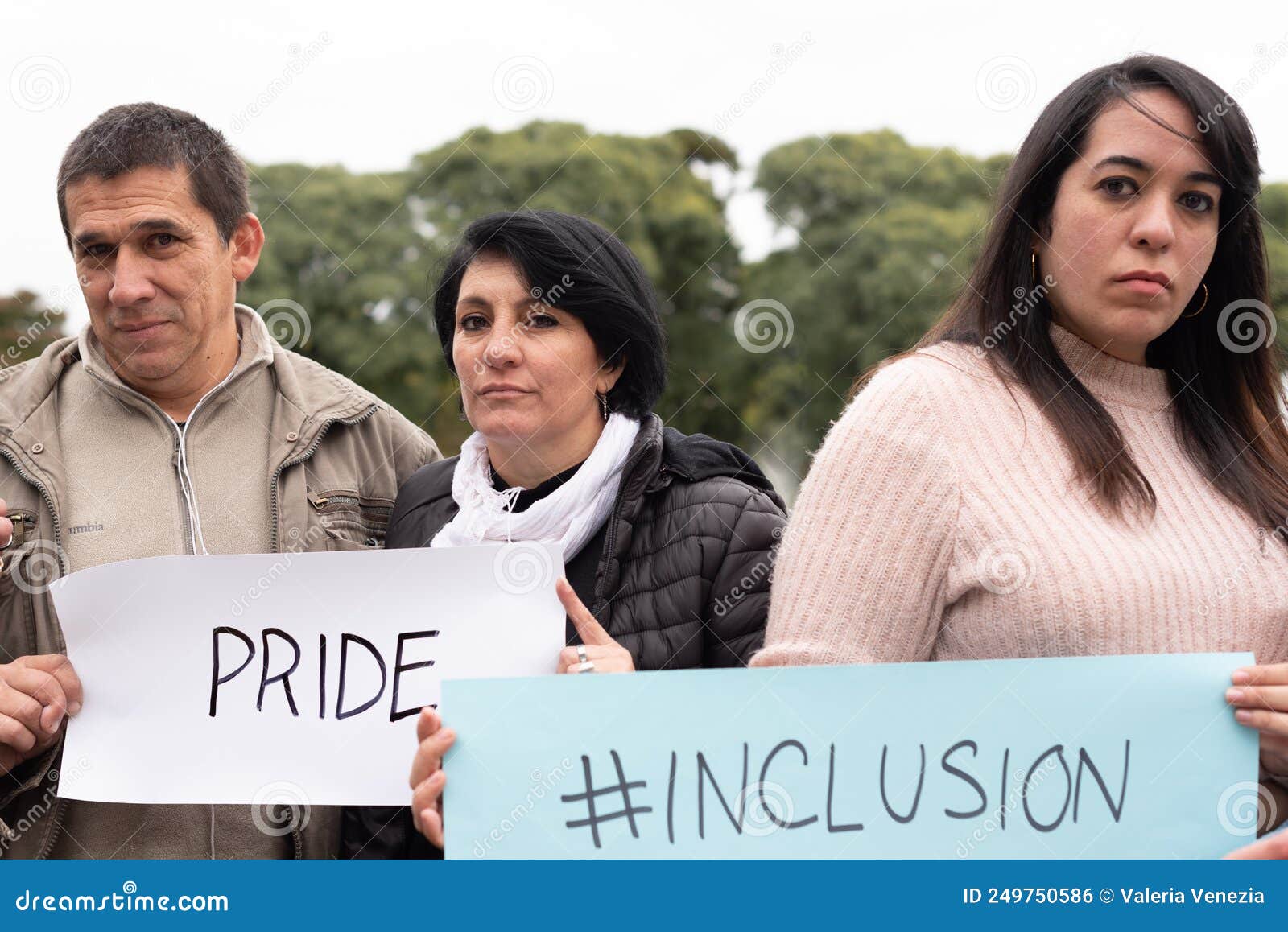 a group of people holding inclusiÃÂ³n and pride signs as a protest. lgbt concept