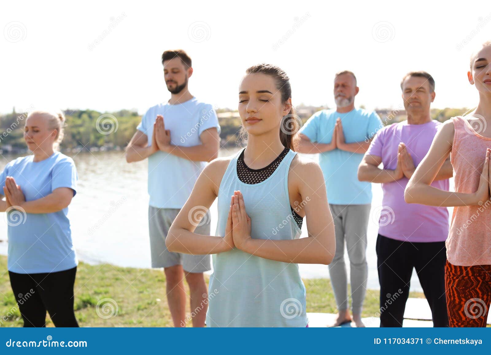 Group Of People Practicing Yoga Near River Stock Photo Megapixl