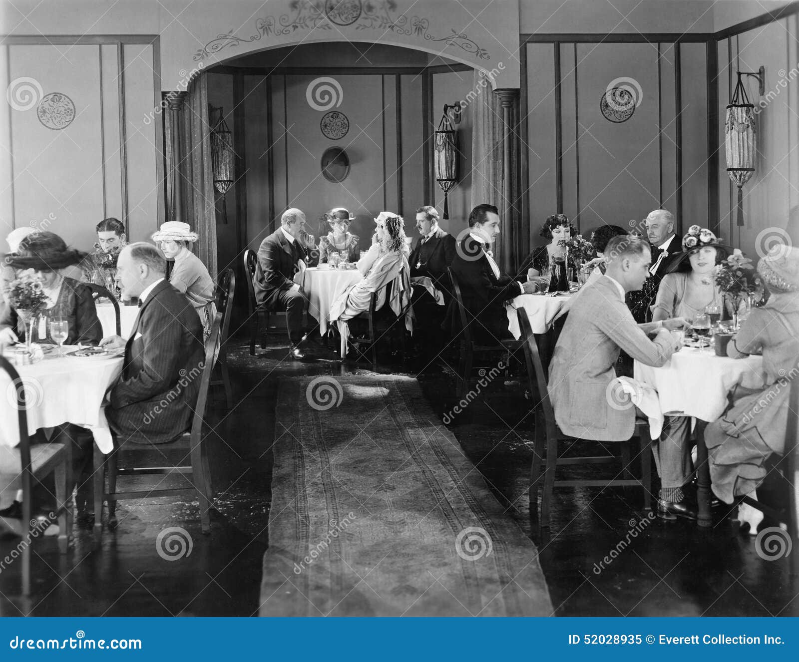 Group of people sitting in a restaurant having dinner (All persons depicted are no longer living and no estate exists. Supplier grants that there will be no model release issues.)