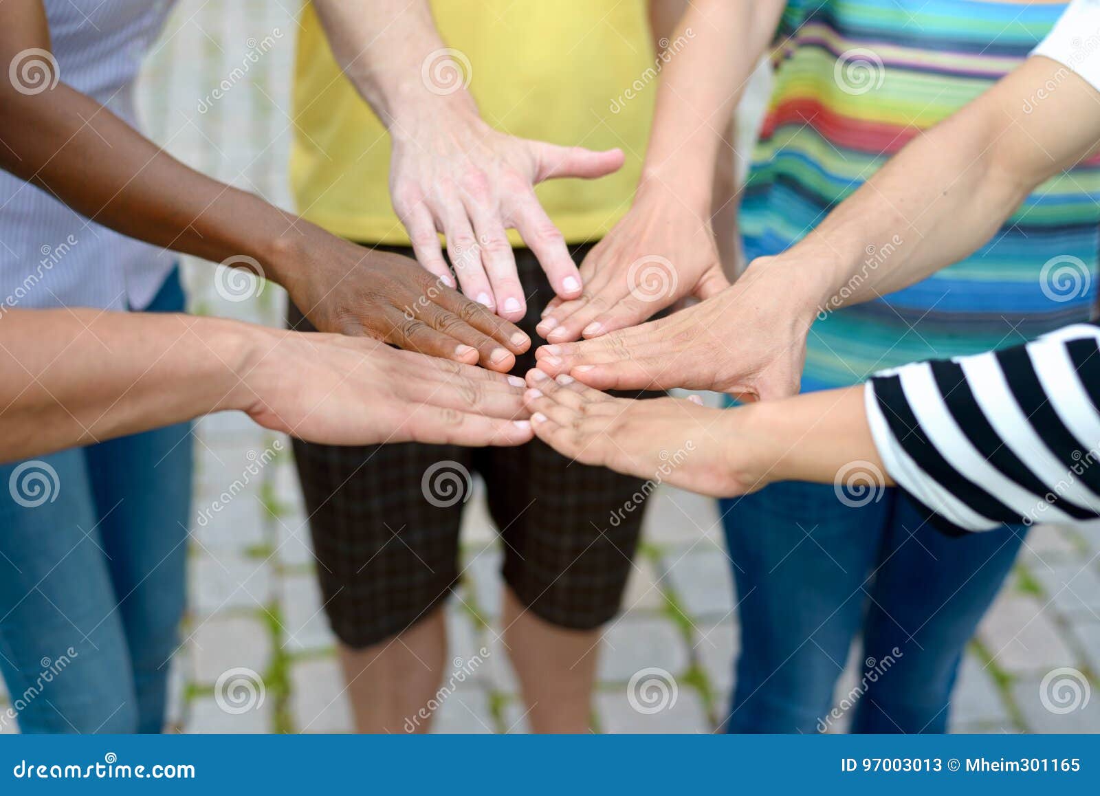 group of people touching hands in a circle