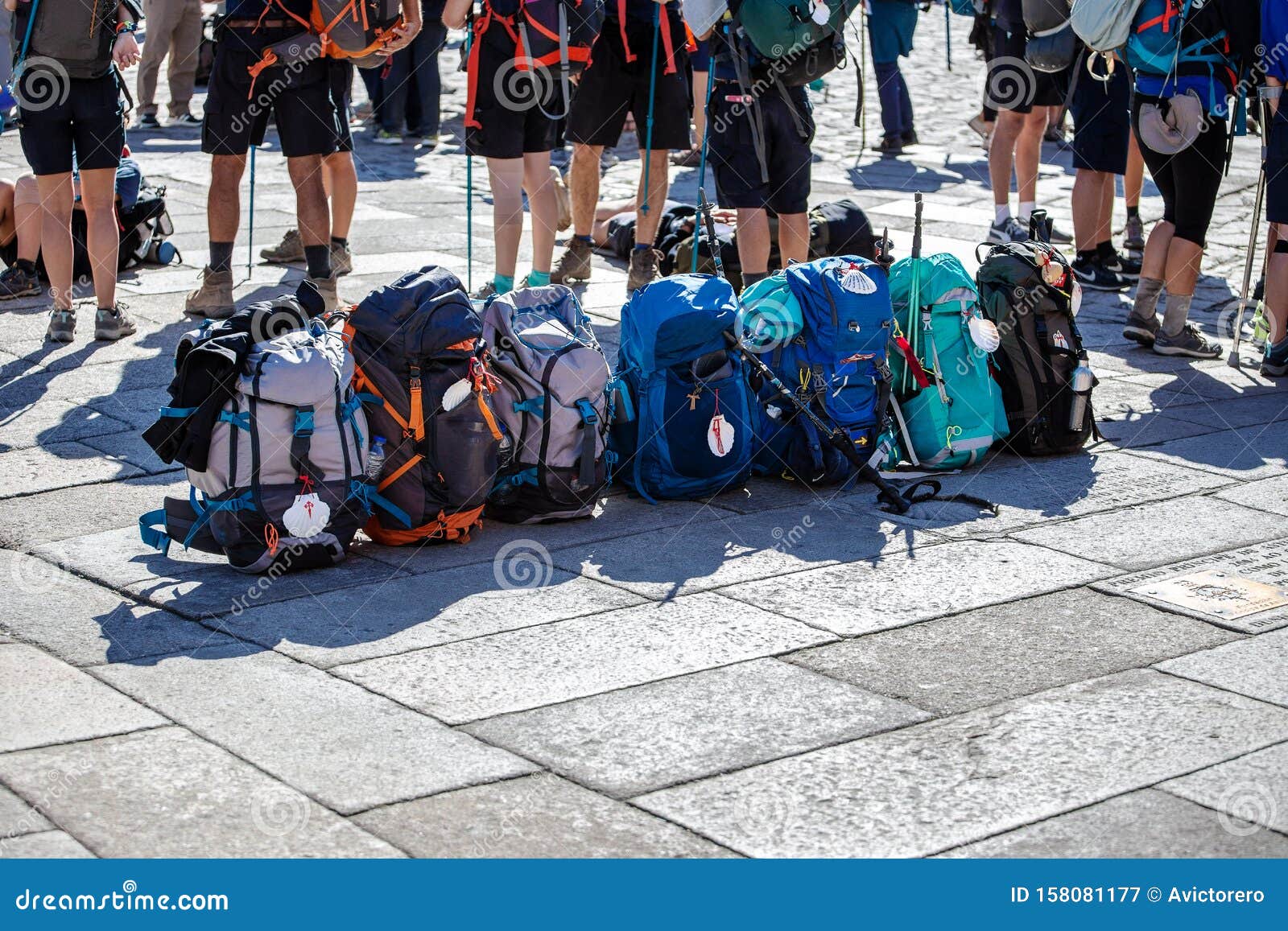 group of pilgrim backpack in a row on paving stone of obradoiro square, santiago de compostela, spain