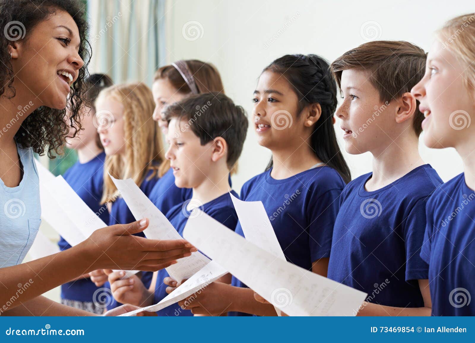 group of school children with teacher singing in choir