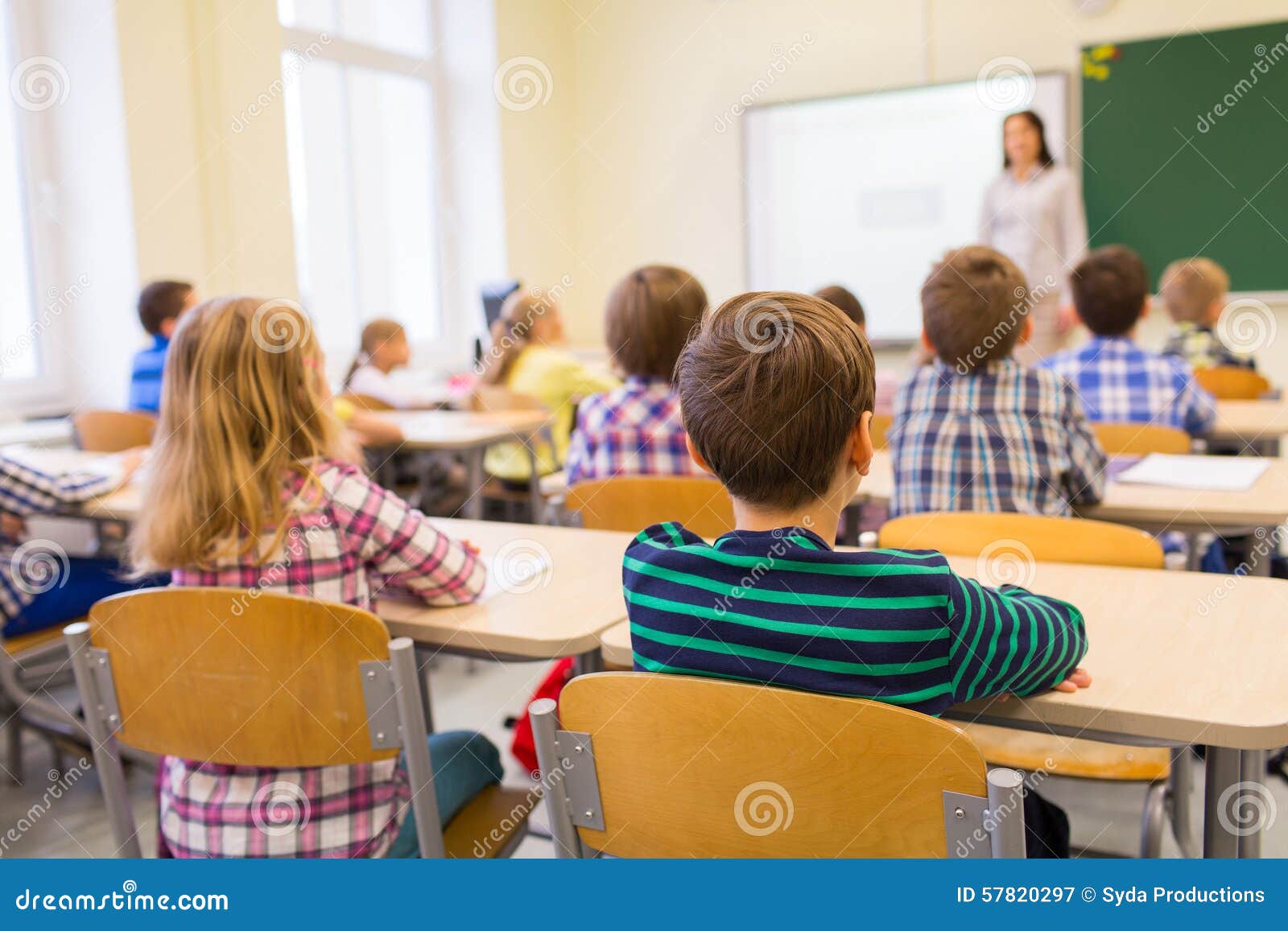 group of school kids and teacher in classroom