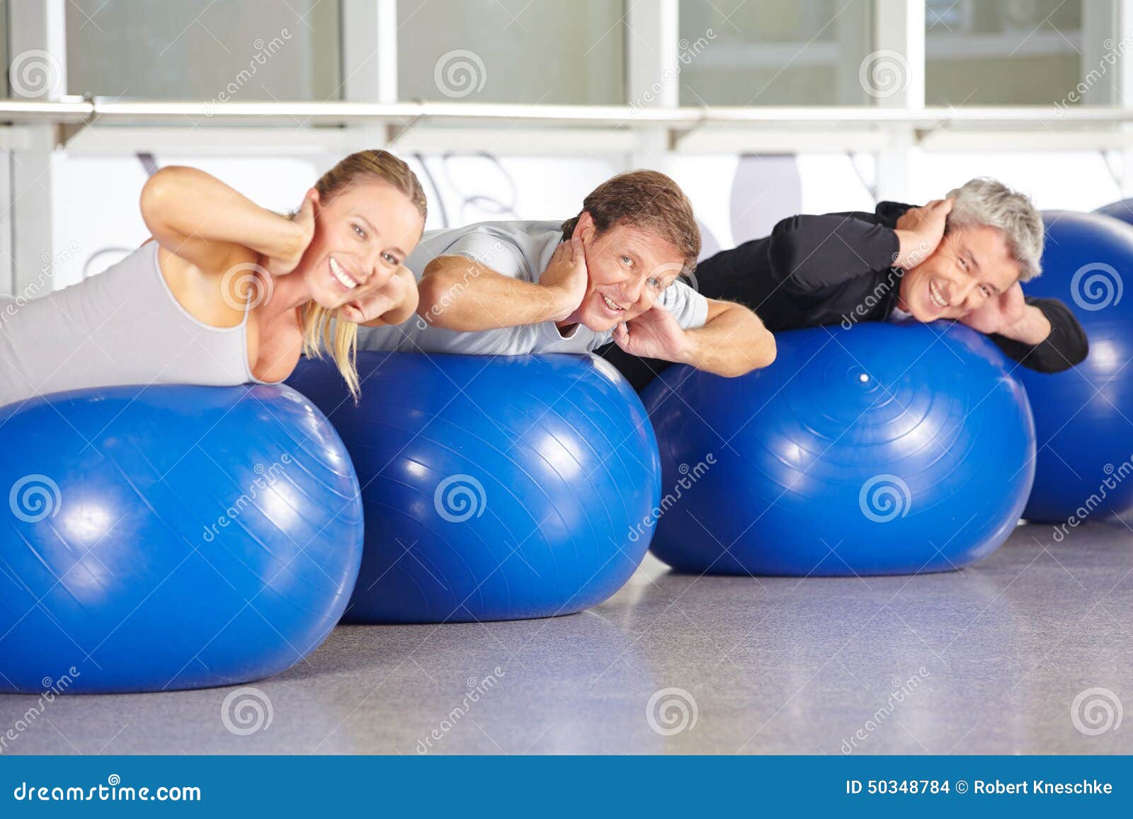 Group of Senior People on Gym Balls Doing Back Training Stock Photo