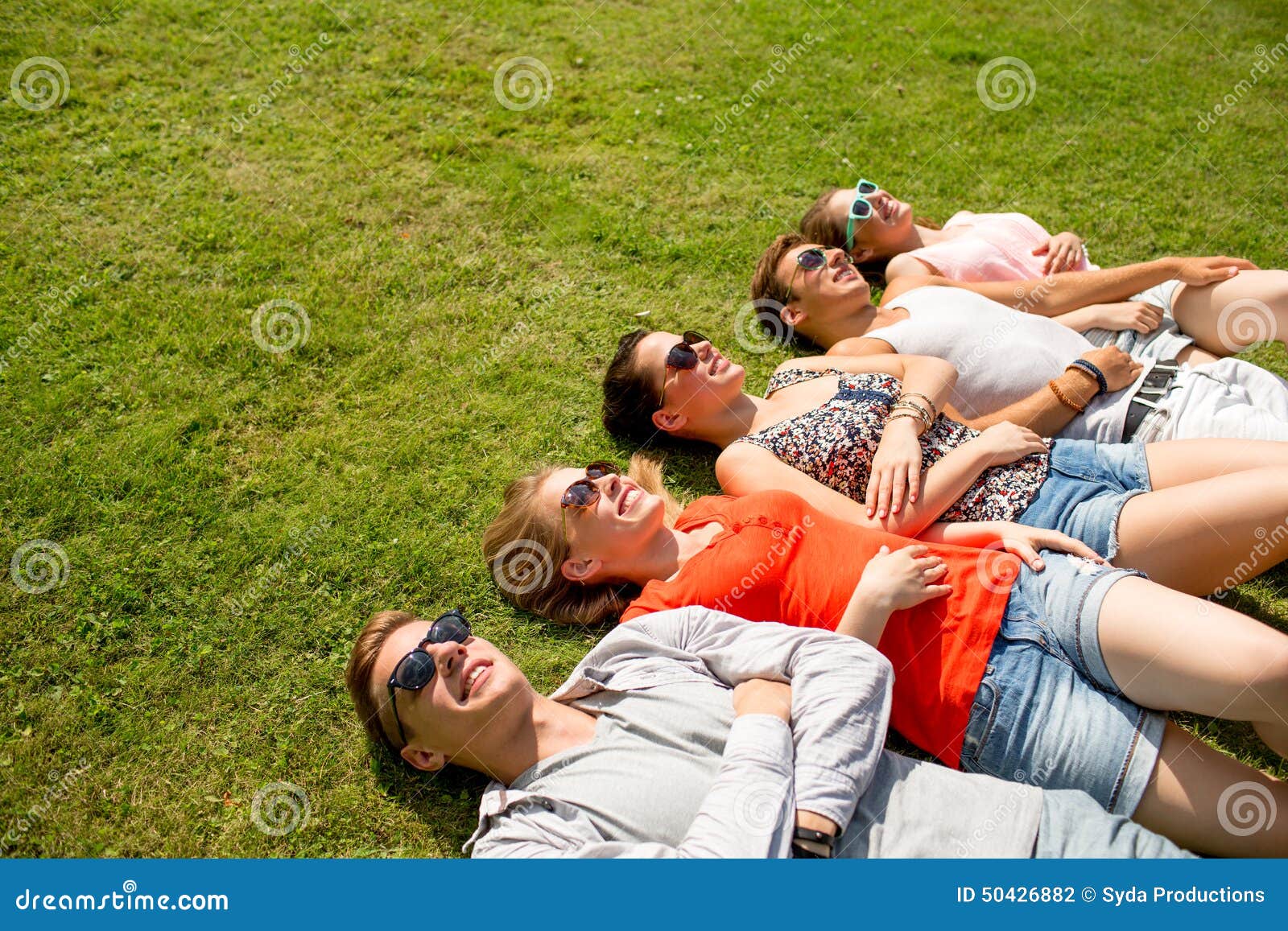 Group Of Smiling Friends Lying On Grass Outdoors Stock Photo Image Of