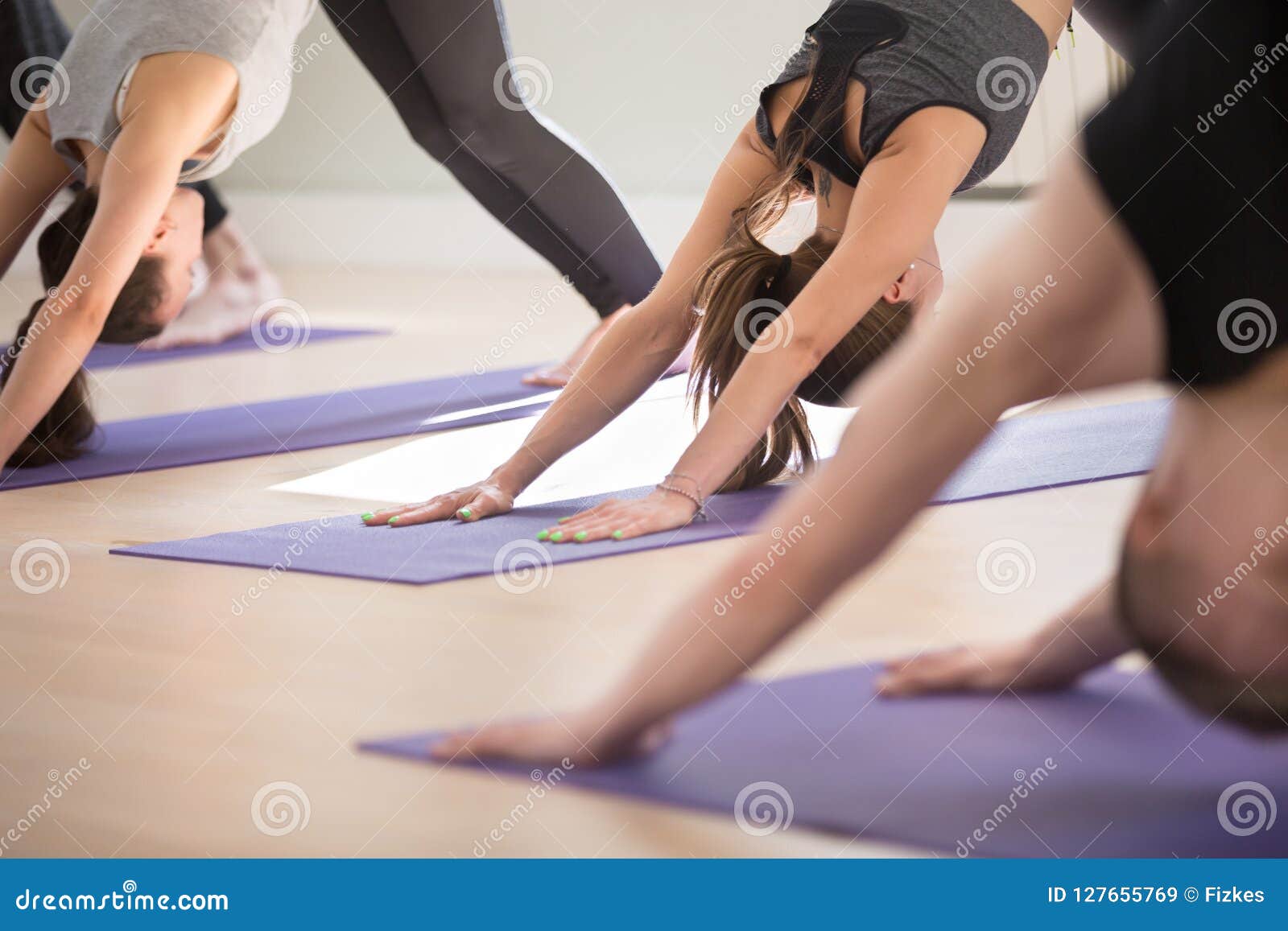 Group of Sporty People Practicing Yoga, Doing Downward Facing Do Stock ...