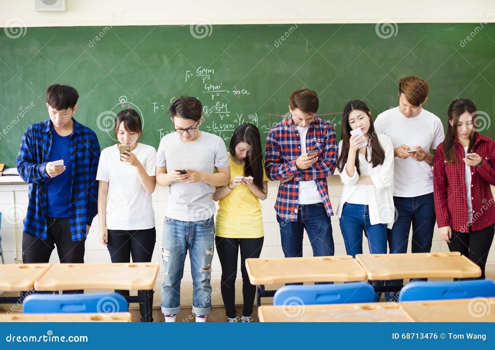 group of students using smart mobile phones in classroom