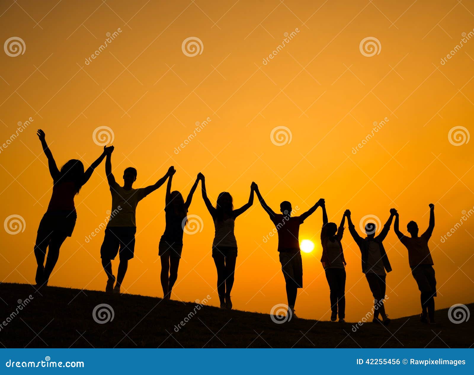 group of teenagers holding hands and celebrate in back lit