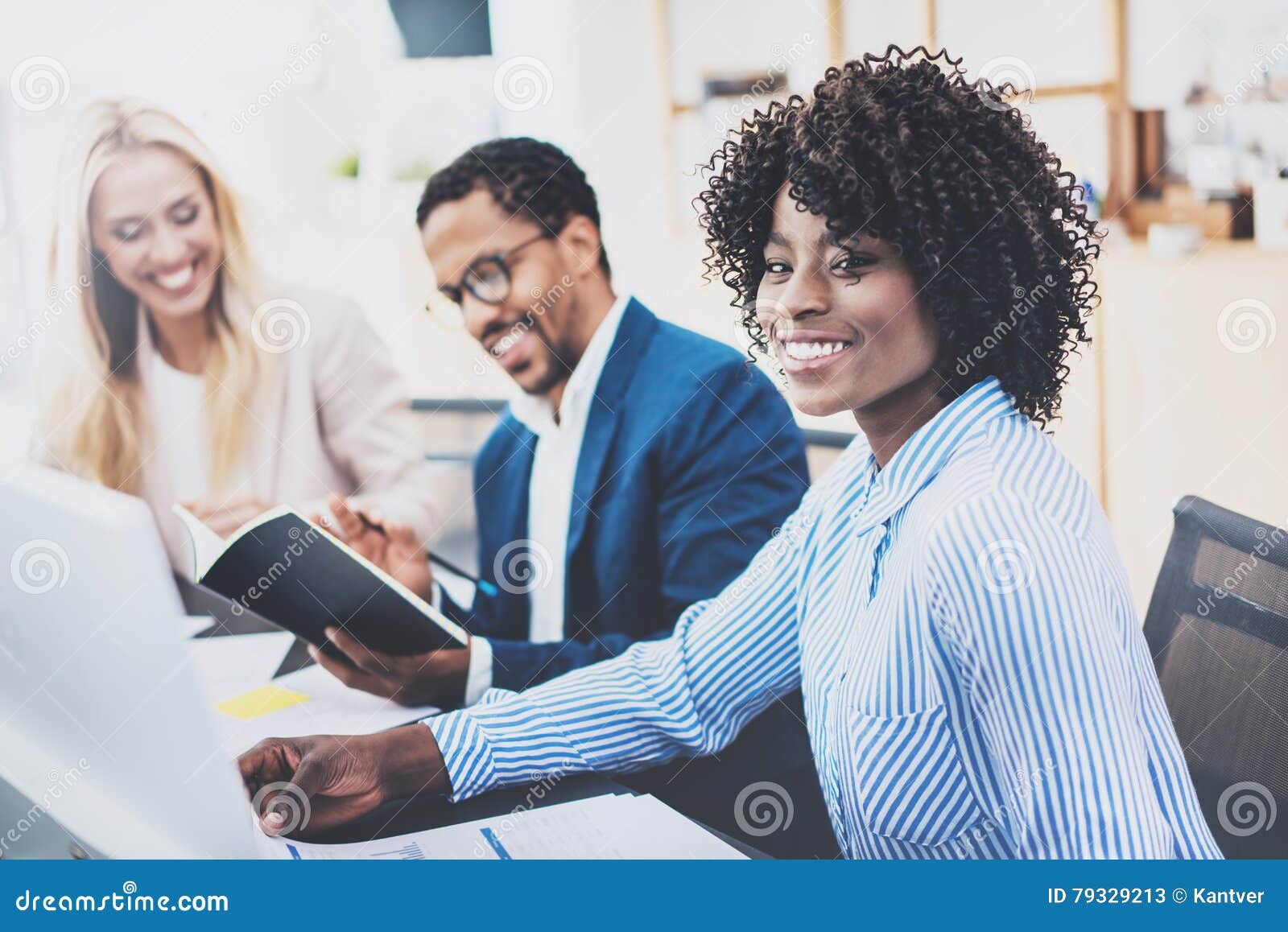 group of three coworkers working together on business project in modern office.young attractive african woman smiling, teamwork co