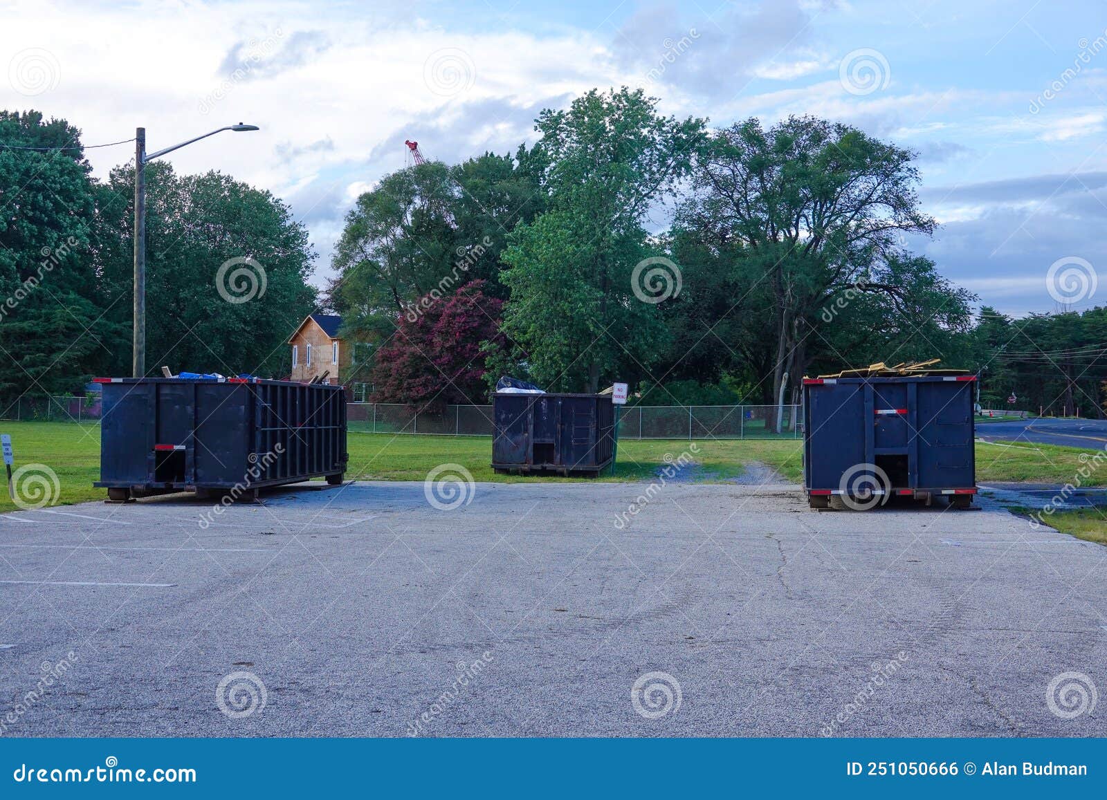 A Group of Three Long Blue Dumpsters Full of Construction Debris in a